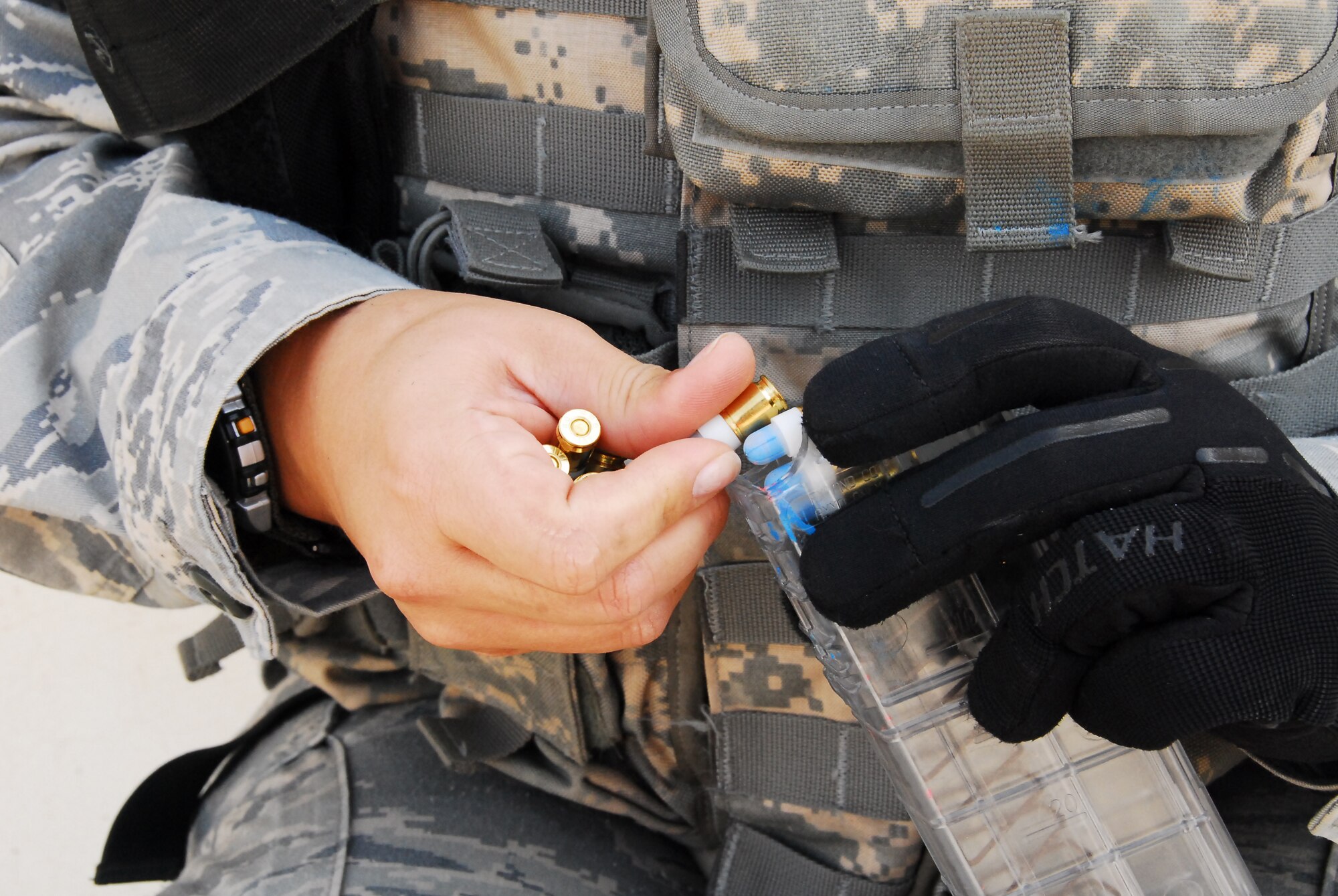 SOUTHWEST ASIA -- Personnel from the 386th Expeditionary Security Forces Squadron load simulated rounds into a training magazine before a Close Quarter Battle drill at an air base in Southwest Asia, March 18. The simulation rounds are 9mm casings with paintball tips designed to give the Airmen a realistic training experience. (U.S. Air Force photo/ Senior Airman Courtney Richardson)