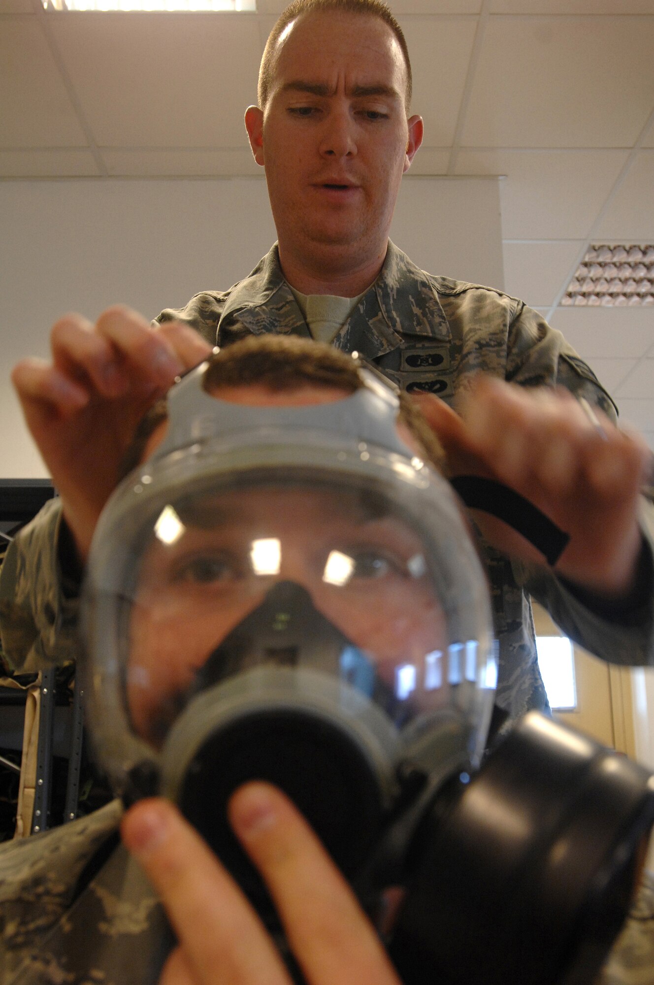 Senior Airman Christopher Gapetz, a 31st Civil Engineer Squadron readiness and emergency management journeyman, tightens the head harness of Senior Airman Samuel Wickersham's MCU-2P Gas Mask during Chemical, Biological, Radiological, Nuclear, and High Yield Explosives survival skills training March 19, here. The Readiness and Emergency Management flight holds the required CBRNE survival skills training classes approximately three times a week with 20-30 people in a class at a time. (U.S. Air Force photo/ Staff Sgt. Patrick Dixon)