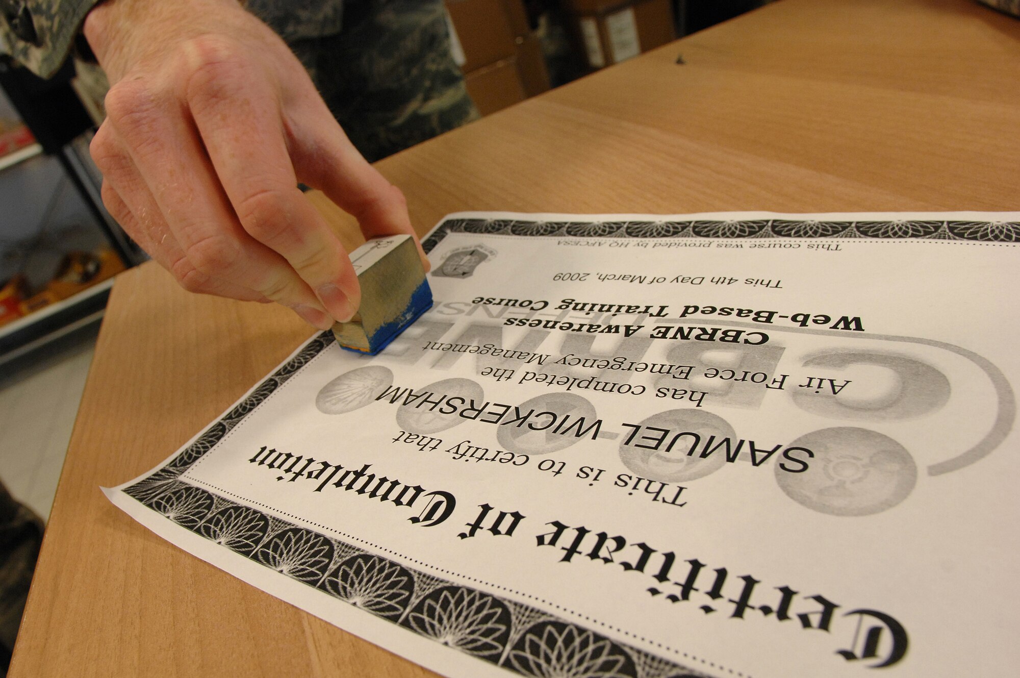 Senior Airman Christopher Gapetz, a 31st Civil Engineer Squadron readiness and emergency management journeyman, uses a stamp to verify completion of training during Chemical, Biological, Radiological, Nuclear, and High Yield Explosives survival skills training March 19, here. The Readiness and Emergency Management flight holds the required CBRNE survival skills training classes approximately three times a week with 20-30 people in a class at a time. (U.S. Air Force photo/ Staff Sgt. Patrick Dixon)