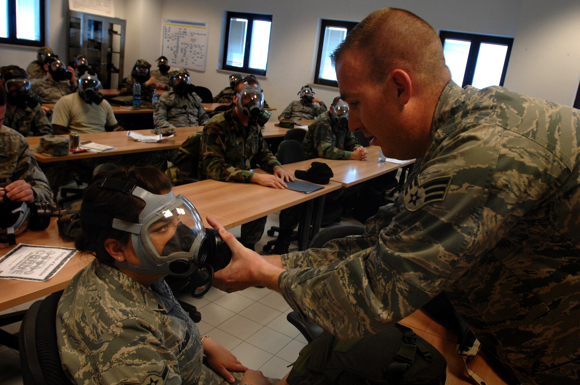 Senior Airman Christopher Gapetz, a 31st Civil Engineer Squadron readiness and emergency management journeyman, checks the seal on Airman Lauren Lagudi's MCU-2P Gas Mask during Chemical, Biological, Radiological, Nuclear, and High Yield Explosives survival skills training March 19, here. The Readiness and Emergency Management flight holds the required CBRNE survival skills training classes approximately three times a week with 20-30 people in a class at a time. (U.S. Air Force photo/ Staff Sgt. Patrick Dixon)