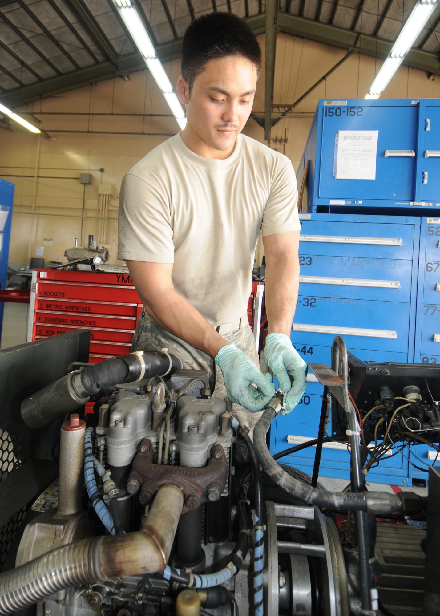 YOKOTA AIR BASE, Japan -- Airman 1st Class Ryuichi Sugaya, 374th Maintenance Squadron aerospace ground equipment apprentice, removes an oil separating housing from an MC2A air compressor March 19. The AGE flight maintains more than 600 pieces of equipment and supplies ground power to aircraft and maintenance crews to help them troubleshoot and repair aircraft. (U.S. Air Force photo/Senior Airman Veronica Pierce)

