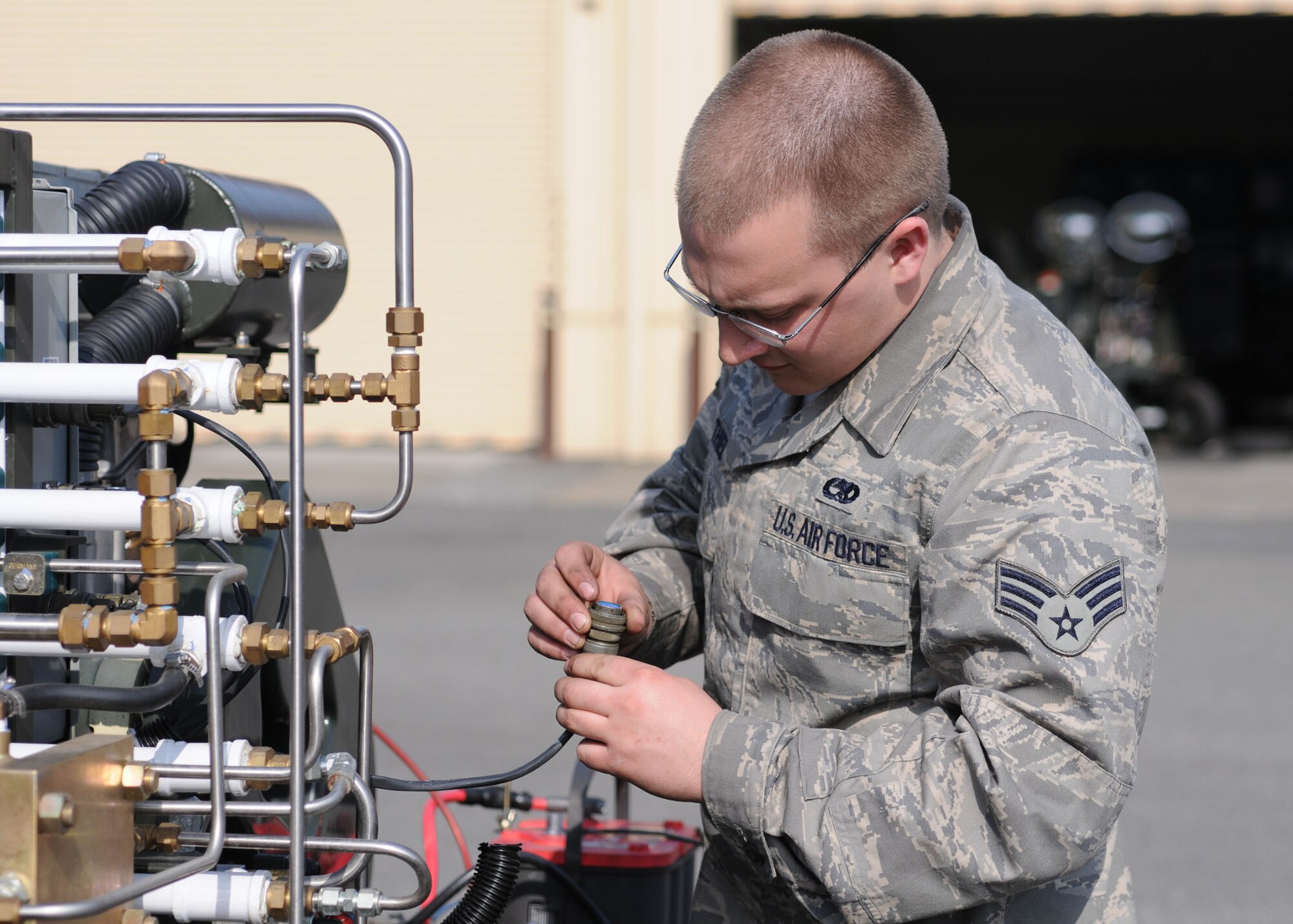 YOKOTA AIR BASE, Japan -- Senior Airman Cory Thiel, 374th Maintenance Squadron aerospace ground equipment journeyman, inspects a cannon plug March 19 on a self-generating nitrogen cart used to inflate aircraft tires. The AGE flight maintains more than 600 pieces of equipment and supplies ground power to aircraft and maintenance crews to help them troubleshoot and repair aircraft. (U.S. Air Force photo/Senior Airman Veronica Pierce)

