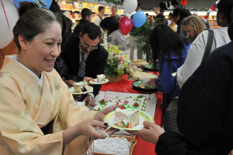 MISAWA AIR BASE, Japan -- Elaine Ortiz-Harrison, American Forces Network Misawa volunteer, hands out cake during the grand opening of the commissary sushi bar March 14, 2009. Many members of the Misawa community came out in support of the event and were treated to a taiko drum team musical performance, prize give-aways and free sushi samples. (U.S. Air Force photo by Capt. Kenneth Gerst)