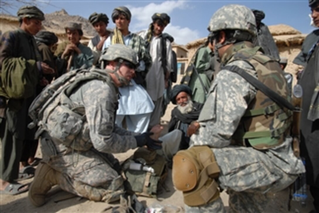 U.S. Army Spc. Chad Brown, a medic assigned to Bravo Company, 1st Battalion, 4th Infantry Regiment, U.S. Army Europe, treats an Afghan elder's foot in a village near Forward Operating Base Baylough, Zabul, Afghanistan, on March 17, 2009.  