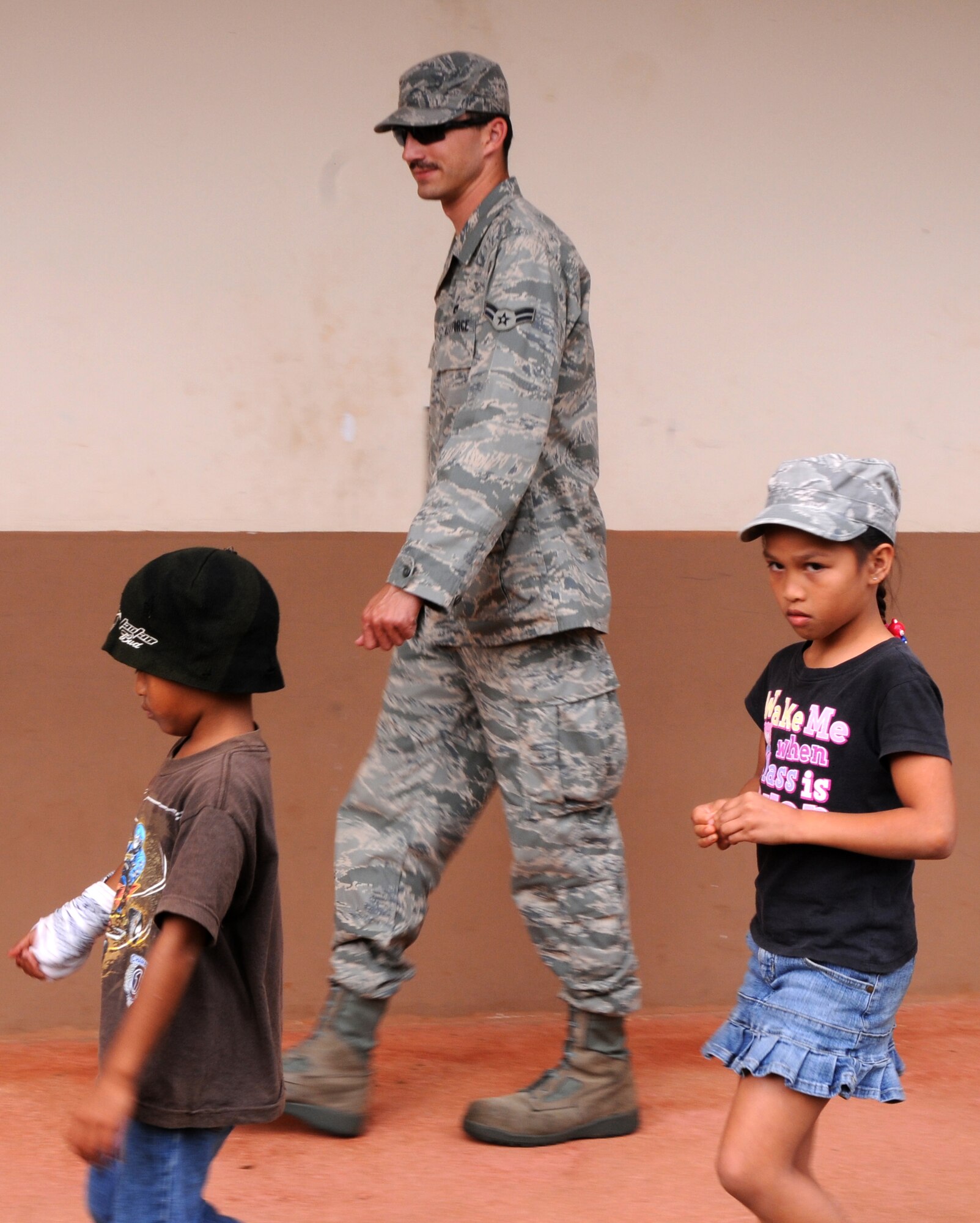 Airman 1st Class Erik Johannas,  36th Expeditionary Aircraft Maintenance Squadron weapon loader, walks 3rd Grade children at Machananao Elementary School to their class March 19, 2009. Airmen from the 36th Expeditionary Aircraft Maintenance Unit, deployed here from Elmendorf Air Force Base, Alaska, have been spending their time bettering the local community of Guam through various volunteer efforts.
(U.S. Air Force photo by Senior Airman Ryan Whitney)