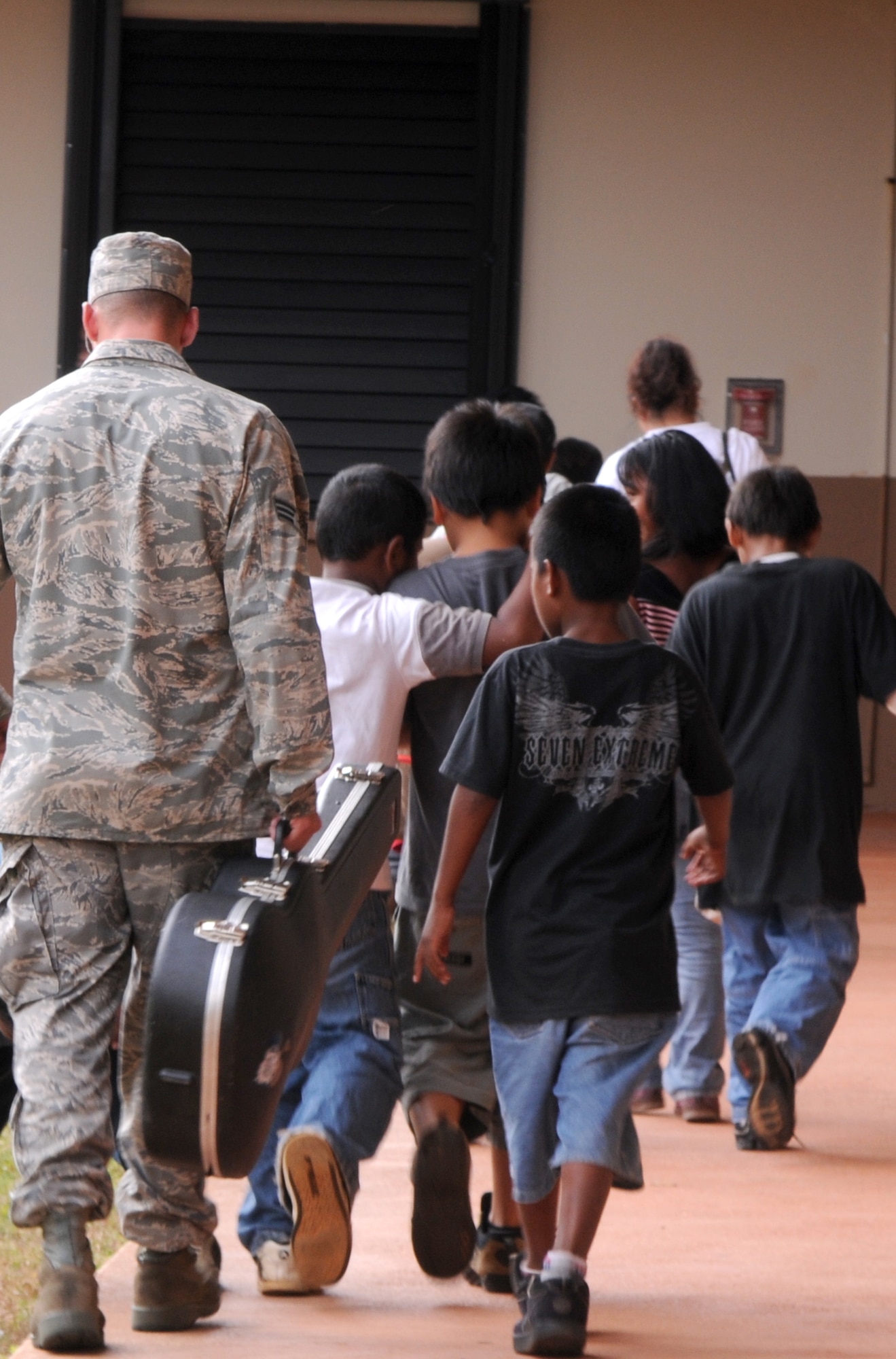 Senior Airman Justin Medige,  36th Expeditionary Aircraft Maintenance Squadron weapon loader, walks third graders at  Machananao Elementary School to class March 19, 2009. Airmen from the 36th Expeditionary Aircraft Maintenance Unit, deployed here from Elmendorf Air Force Base, Alaska, have been spending their time bettering the local community of Guam through various volunteer efforts.
(U.S. Air Force photo by Senior Airman Ryan Whitney)