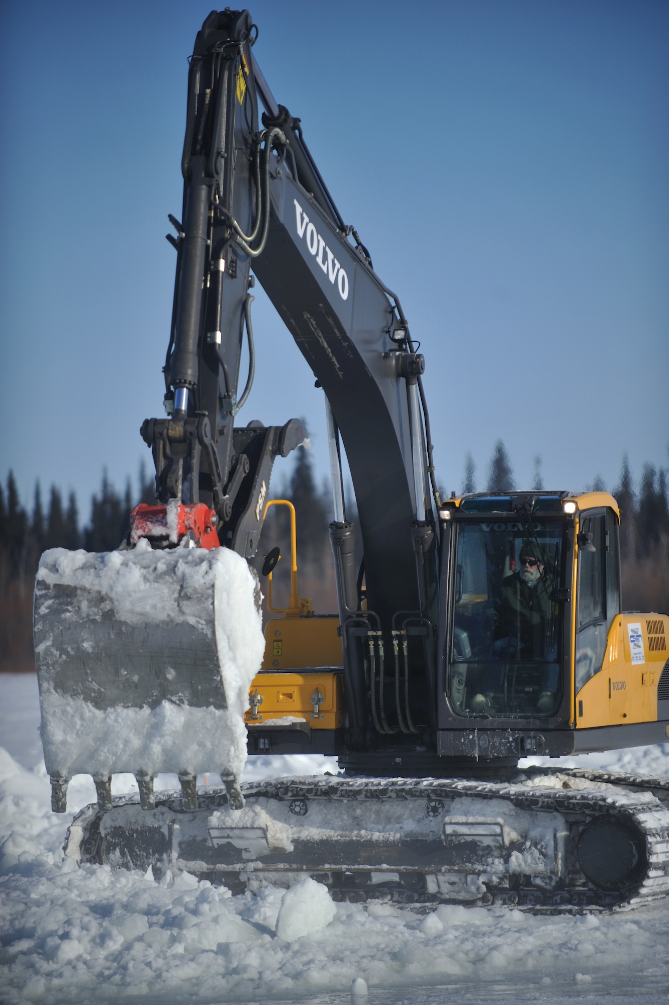 GALENA, Alaska-- Don Smith, a Marsh Creek LLC employee, unloads snow onto the Yukon River, March 19. Marsh Creek LLC, a contractor for the 611th Civil Engineer Squadron, is building an ice bridge to move supplies for demolition of the former Kalakaket Creek Radio Relay Station that is located 310 miles northwest of Anchorage. The station was built in 1957 and was used to transfer defense communications between White Alice Communication Systems up for demolition because of satellite technology in mid 1970s. (U.S. Air Force photo by Senior Airman Jonathan Steffen)