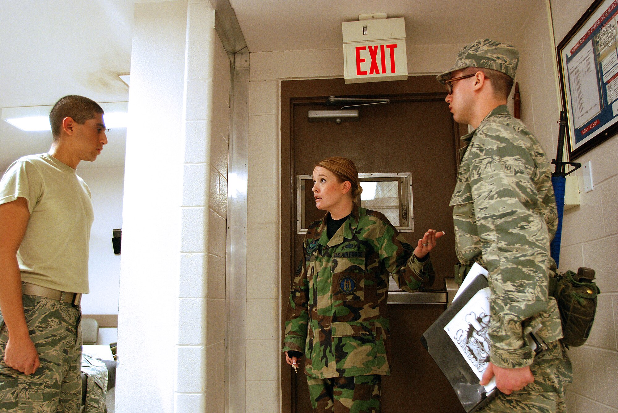 Technical sergeant Allison Chavez, a Reservist military training instructor from the 433rd Airlift Wing, guides two basic trainees on proper entry control procedures. Reservists work in concert with active-duty personnel helping incoming trainees become Airmen. (U.S. Air Force Photo/Airman Brian McGloin)