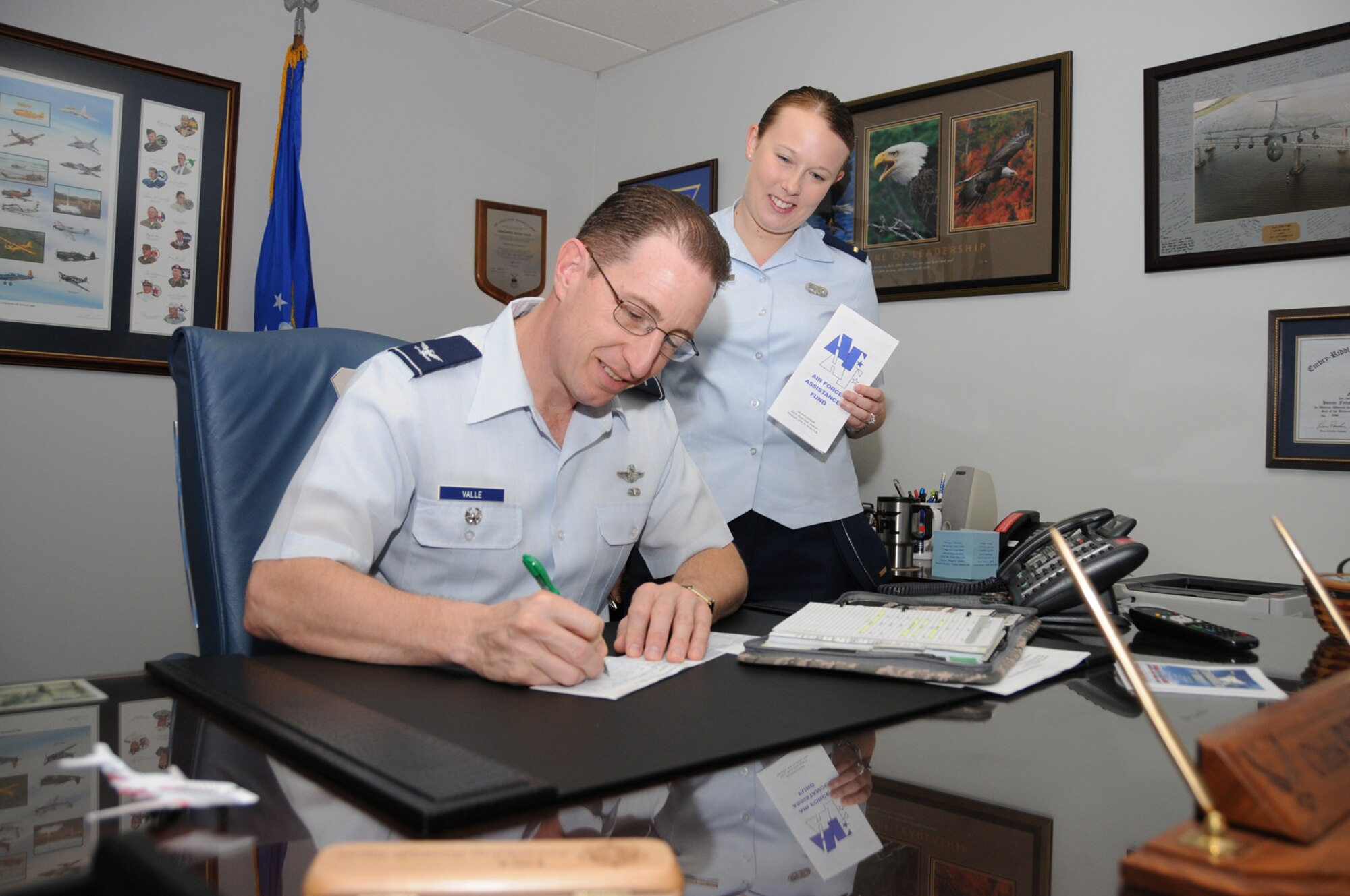 Col. Christopher Valle, 81st Training Wing vice commander, signs an Air Force Assistance Fund pledge form for 2nd Lt. Laura Piranio, 81st Logistics Readiness Squadron, installation project officer.  The drive continues through April 24. (U.S. Air Force photo by Kemberly Groue)