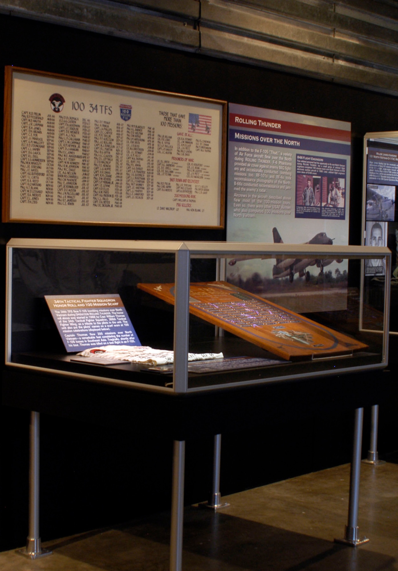 DAYTON, Ohio - 34th Tactical Fighter Squadron Honor Roll and 100 Mission Scarf, 20th Tactical Reconnaissance Squadron Honor Roll and 20th TRS patch on display in the 100 Missions Up North exhibit in the Southeast Asia War Gallery at the National Museum of the U.S. Air Force. (U.S. Air Force photo)