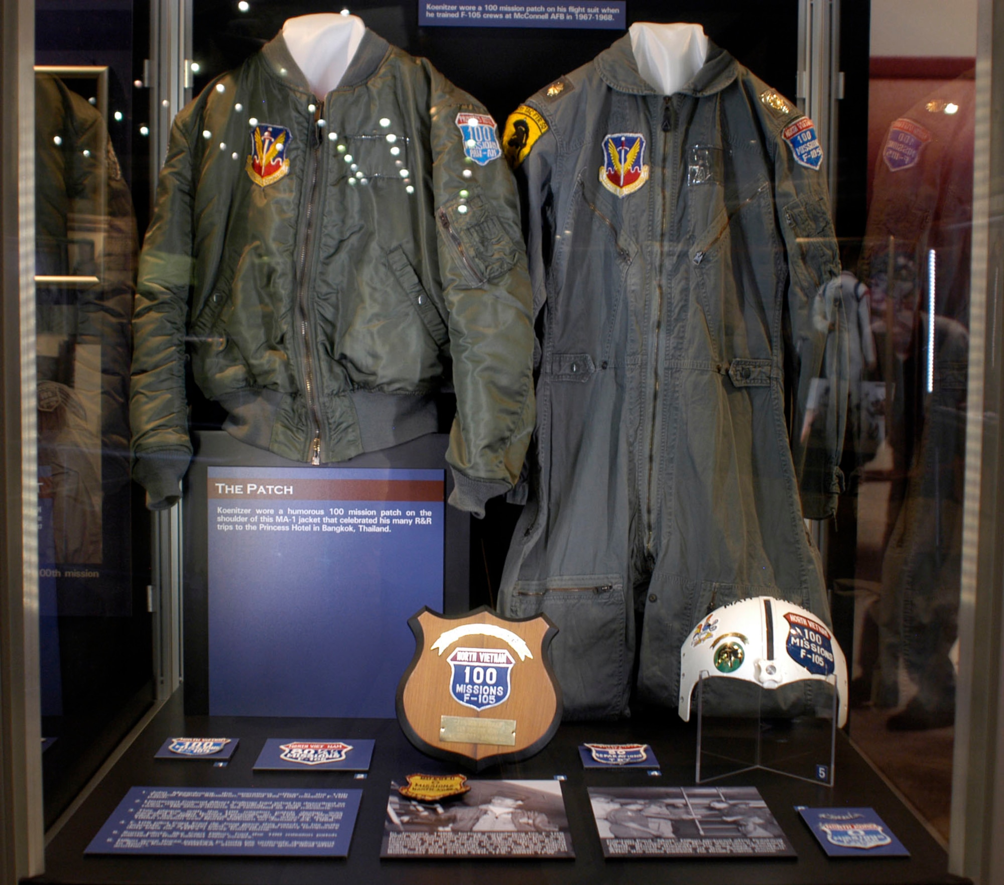 DAYTON, Ohio - On display: Maj. Koenitzer wore a 100-mission patch on his flight suit when he trained F-105 crews at McConnell AFB in 1967-1968. Koenitzer wore a humorous “100-mission” patch on the shoulder of his MA-1 jacket that celebrated his many R&R trips to the Princess Hotel in Bangkok, Thailand. John Mesenbourg, the operations officer in the 13th Tactical Fighter Squadron, earned this 100 mission F-105 patch. Lt. Col. Albert Vollmer had what he described as “two missions without a landing“ (he was shot down twice). His shoot-downs are recorded as half missions. This plaque with the 100-mission patch design was awarded to Capt. Robert Dorrough, an F-105 Wild Weasel pilot in the 388th Tactical Fighter Wing, when he flew his 100th mission over North Vietnam on Jan. 24, 1968. Some pilots, like Capt. Paul "Matt" Dillon, had the 100-mission patch painted on their helmet visor covers. Dillon wore these patches to note his untimely deployment to South Korea. “OGDAA” stood for “one good deal after another.” (U.S. Air Force photo)