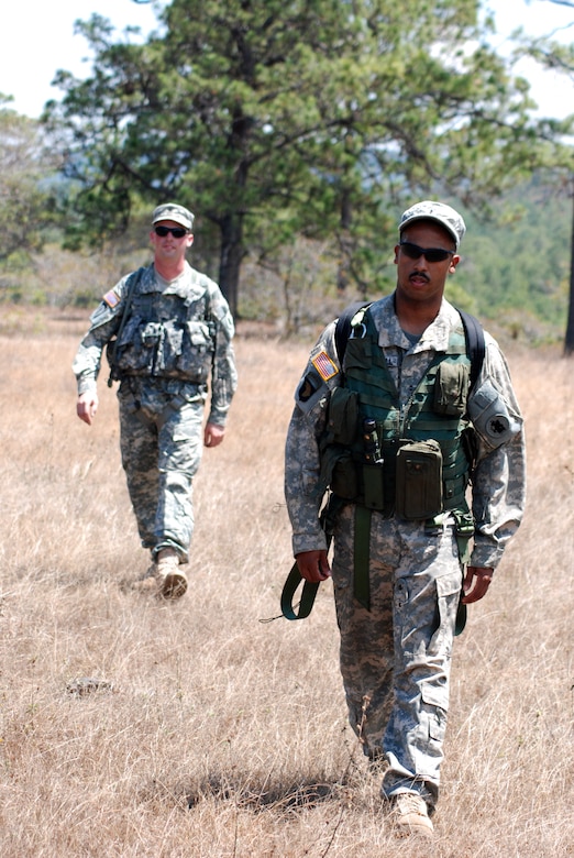 U.S. Army Chief Warrant Officer Timothy Forrestal and Army Spc. James Ferguson hike across a clearing during the final leg of their team's trek March 20 in the wooded area near La Paz, Honduras. The aircrew members were part of five teams of aviators practicing land navigation, ground-to-air communication, and extraction procedures during an exercise conducted by Alpha Company, 1st Battalion, 228th Aviation Regiment assigned to Joint Task Force-Bravo at Soto Cano Air Base, Honduras. (U.S. Air Force photo/Tech. Sgt. Mike Hammond)