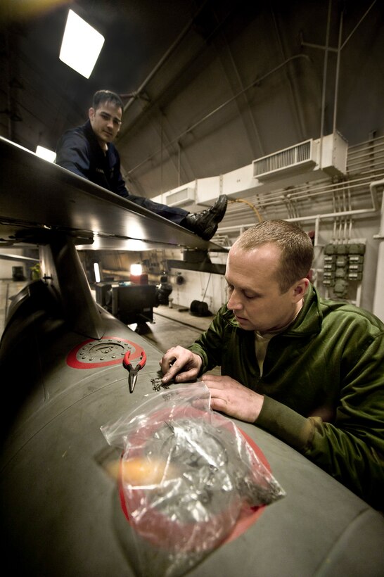 Technical Sgt. Nathan Bechdolt grabs a safety clip to repair the leading edge flap of an F-16 Fighting Falcon as Staff Sgt. William Thomas works on the wing March 6 at Misawa Air Base, Japan. Sergeant Bechdolt is an F-16 crew chief deployed from the Air National Guard's 122nd Fighter Wing from Fort Wayne, Ind. Sergeant Thomas is a 14th Aircraft Maintenance Unit crew chief. (U.S. Air Force photo/Staff Sgt. Samuel Morse) 
