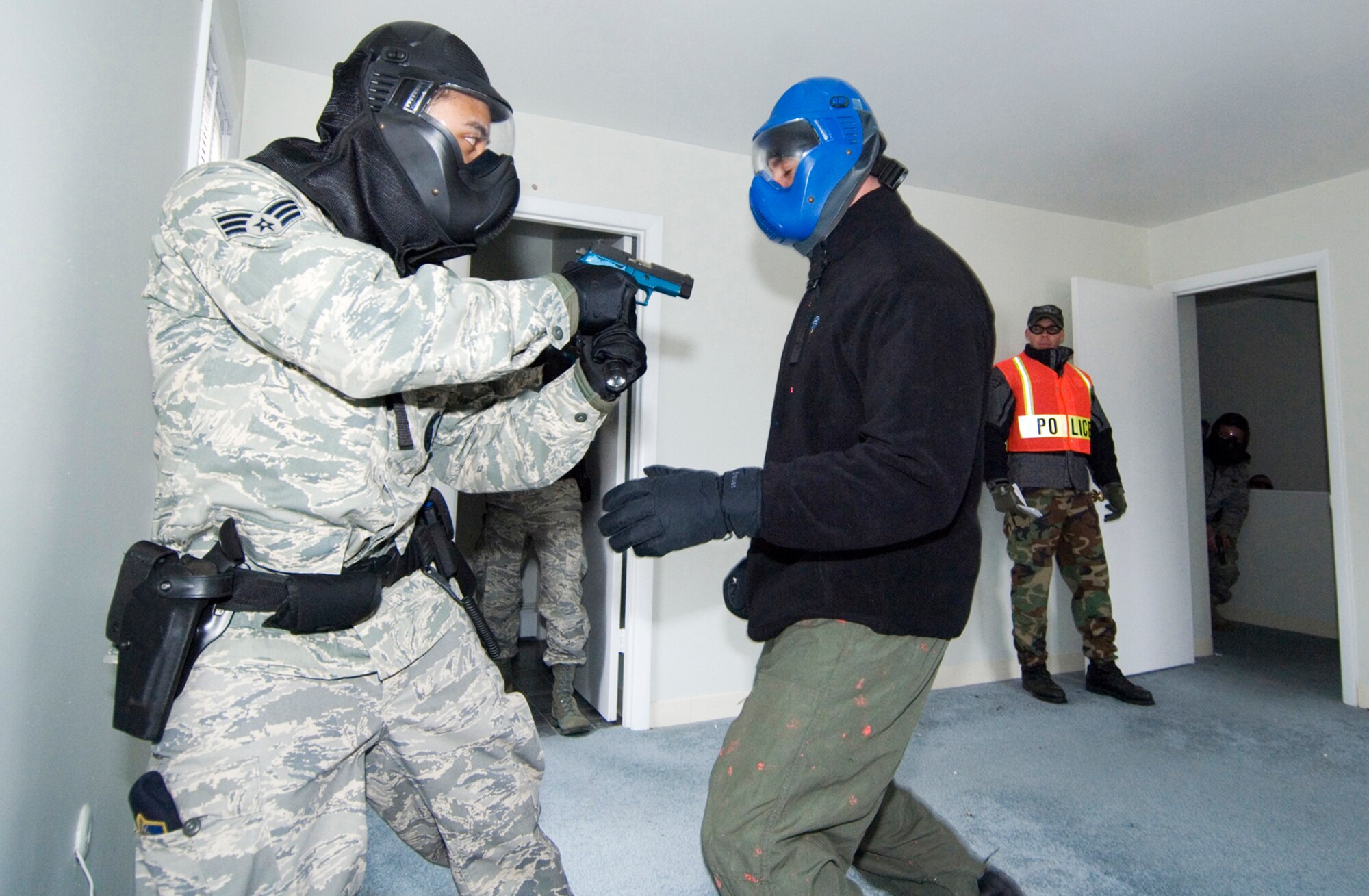 Senior Airman Jonathan Melendez fires a Simunition round at Massachusetts State Police Trooper Dan O'Brian who was playing the role of a dangerous armed suspect who refused to respond to Airman Melendez's orders March 16 at Hanscom Air Force Base, Mass. The scenario was part of the first joint police training between Hanscom AFB security forces and local law enforcement agencies. Airman Melendez is assigned to the 66th Security Forces Squadron. (U.S. Air Force photo/Rick Berry) 

