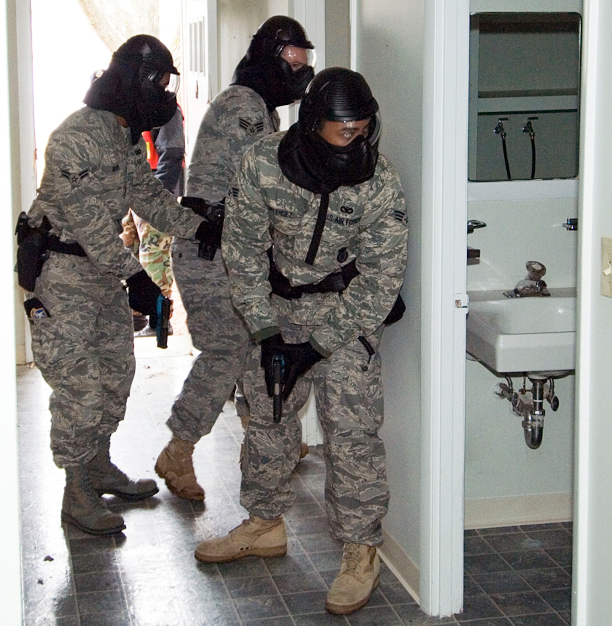 Patrolmen from the 66th Security Forces Squadron practice their search techniques while looking for an armed suspect during a joint police training exercise March 16 at Hanscom Air Force Base, Mass. The training provided an opportunity for SFS patrolmen and members of the Lexington, Mass., Police Department to train side by side, enhancing familiarization with each others' procedures and tactics. (U.S. Air Force photo/Rick Berry) 
