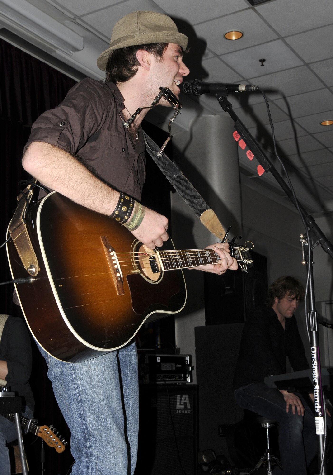 Stephen Kellogg, lead vocals for “Stephen Kellogg and the Sixers,” incorporates a harmonica into the song during a performance March 20 at Incirlik’s Consolidated Club.  Both Stephen Kellogg and Andrew Ripp bands used non-mainstream instruments in their music. (U.S. Air Force photo/Airman 1st Class Amber Russell)