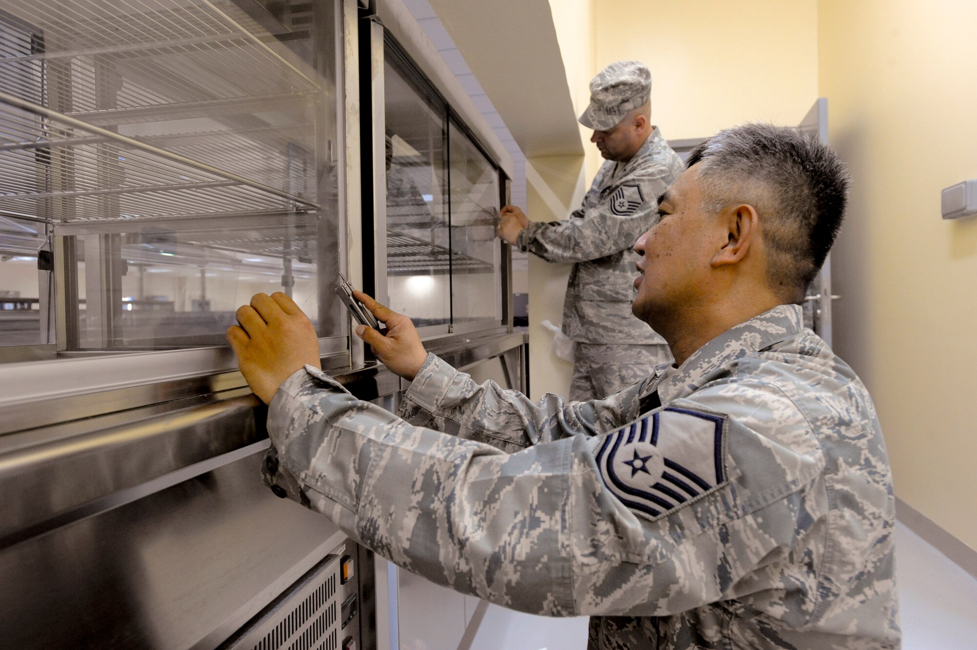Master Sgt. Ramon Erpelo and Master Sgt. Robert Campbell, both from the 379th Expeditionary Force Support Squadron, sanitize and set up equipment in the new Coalition Compound dining facility, March 23, 2009, in an undisclosed location in Southwest Asia. The new dining facility, scheduled to open soon, will have a state of the art kitchen to feed the servicemembers stationed here.  Sergeant Eperlo is native to Chicago, Ill. and is deployed from McChord Air Force Base, Wash. while Sergeant Campbell is native to Anchorage, Alaska and deployed from Elmendorf Air Force Base, Alaska, both in support of Operations Iraqi and Enduring Freedom and Combined Joint Task Force - Horn of Africa.  (U.S. Air Force Photo by Staff Sgt. Joshua Garcia/released)