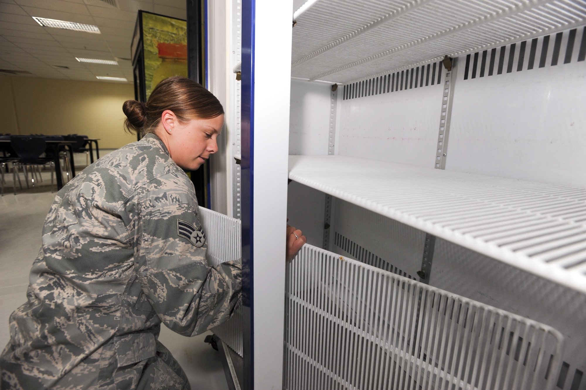Senior Airman Mandy Woodard, a services journeyman with the 379th Expeditionary Force Support Squadron, sets up a beverage refrigerator in the new Coalition Compound dining facility in preparation for the grand opening, March 23, 2009, in an undisclosed location in Southwest Asia.  Airman Woodard and fellow EFSS members are moving equipment to the new dining facility while still having to complete their regular duties at their own work place.  Airman Woodard hails from Stark, N.H. and is deployed from Pease Air National Guard Base, N.H. in support of Operations Iraqi and Enduring Freedom and Combined Joint Task Force - Horn of Africa.(U.S. Air Force Photo by Staff Sgt. Joshua Garcia/released)