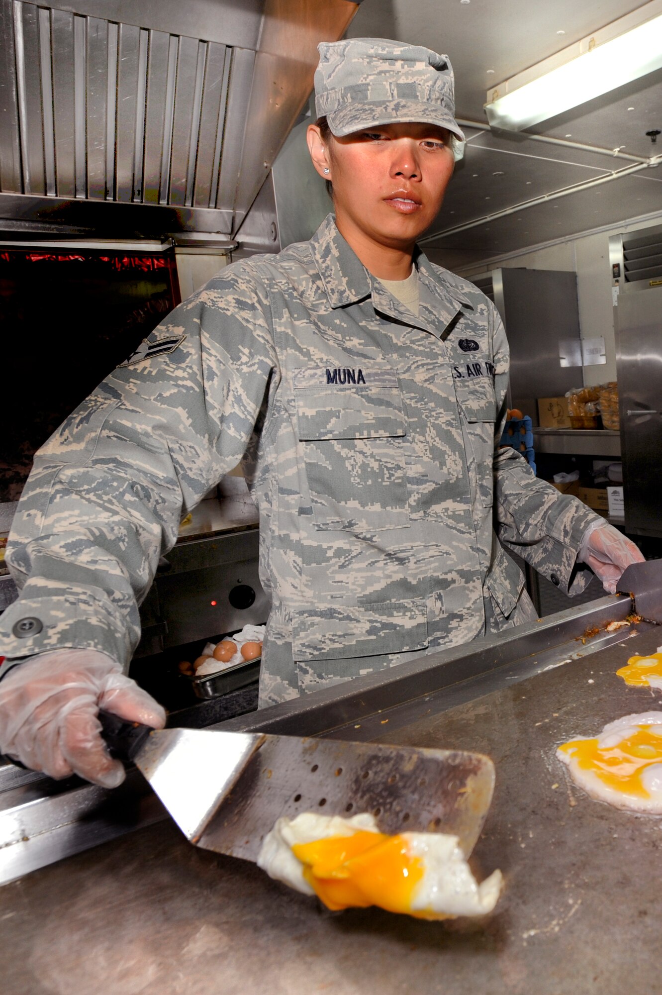 Airman 1st Class Jolene Muna, a services journeyman with the 379th Expeditionary Force Support Squadron, cooks eggs for a patron at the Coalition Compound dining facility, March 23, 2009, in an undisclosed location in Southwest Asia.  Airman Muna is native to Ipan, Guam and is deployed from Anderson Air Force Base, Guam in support of Operations Iraqi and Enduring Freedom and Combined Joint Task Force - Horn of Africa. (U.S. Air Force Photo by Staff Sgt. Joshua Garcia/released)