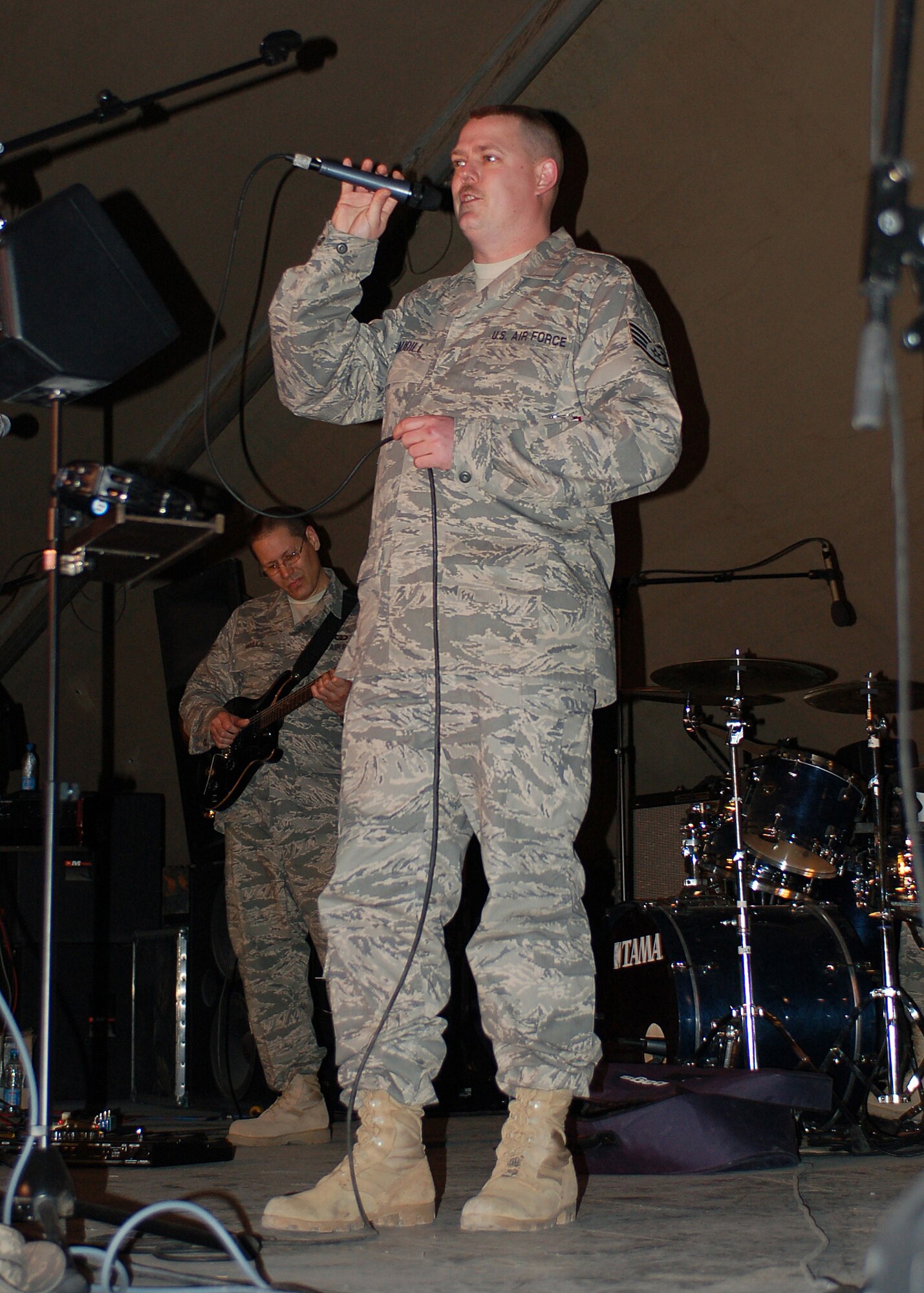 Staff Sgt. Eric Caudill belts out a tune as a guest vocalist during a performance by the band Sirocco, a U.S. Air Forces Central Expeditionary Band, during their final show at Manas Air Base, Kyrgyzstan, March 21. Sirocco is deployed to Southwest Asia from the U.S. Air Forces in Europe Band at Sembach AB, Germany. Sergeant Caudill is assigned to the 22md Expeditionary Air Refueling Squadron and is deployed from Elmendorf Air Force Base, Alaska.  He is a native of Warner Robins, Ga. (U.S. Air Force photo/Tech. Sgt. Elizabeth Weinberg)