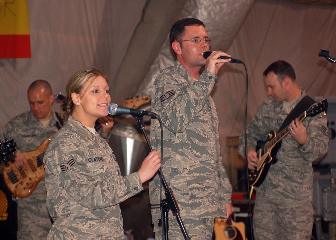 Vocalists Senior Airman Courtney Clifford and Staff Sgt. Geoff Fisher, accompanied by bass player Staff Sgt. Mark Frandsen, and guitarist Staff Sgt. Gene Dooley, belt out a tune for coalition forces during one of their final performance at Manas Air Base, Kyrgyzstan, March 21. Sirocco, the U.S. Air Forces Central Expeditionary Band is deployed to Southeast Asia from the U.S. Air Forces in Europe Band at Sembach AB, Germany. (U.S. Air Force photo/Tech. Sgt. Elizabeth Weinberg) 
