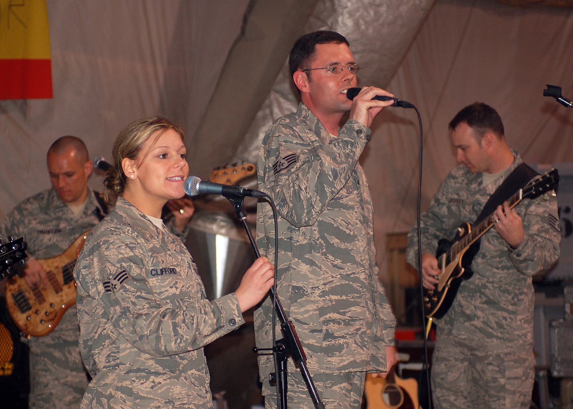 Vocalists Senior Airman Courtney Clifford and Staff Sgt. Geoff Fisher, accompanied by bass player Staff Sgt. Mark Frandsen, and guitarist Staff Sgt. Gene Dooley, belt out a tune for coalition forces during one of their final performance at Manas Air Base, Kyrgyzstan, March 21. Sirocco, the U.S. Air Forces Central Expeditionary Band is deployed to Southeast Asia from the U.S. Air Forces in Europe Band at Sembach AB, Germany. (U.S. Air Force photo/Tech. Sgt. Elizabeth Weinberg) 