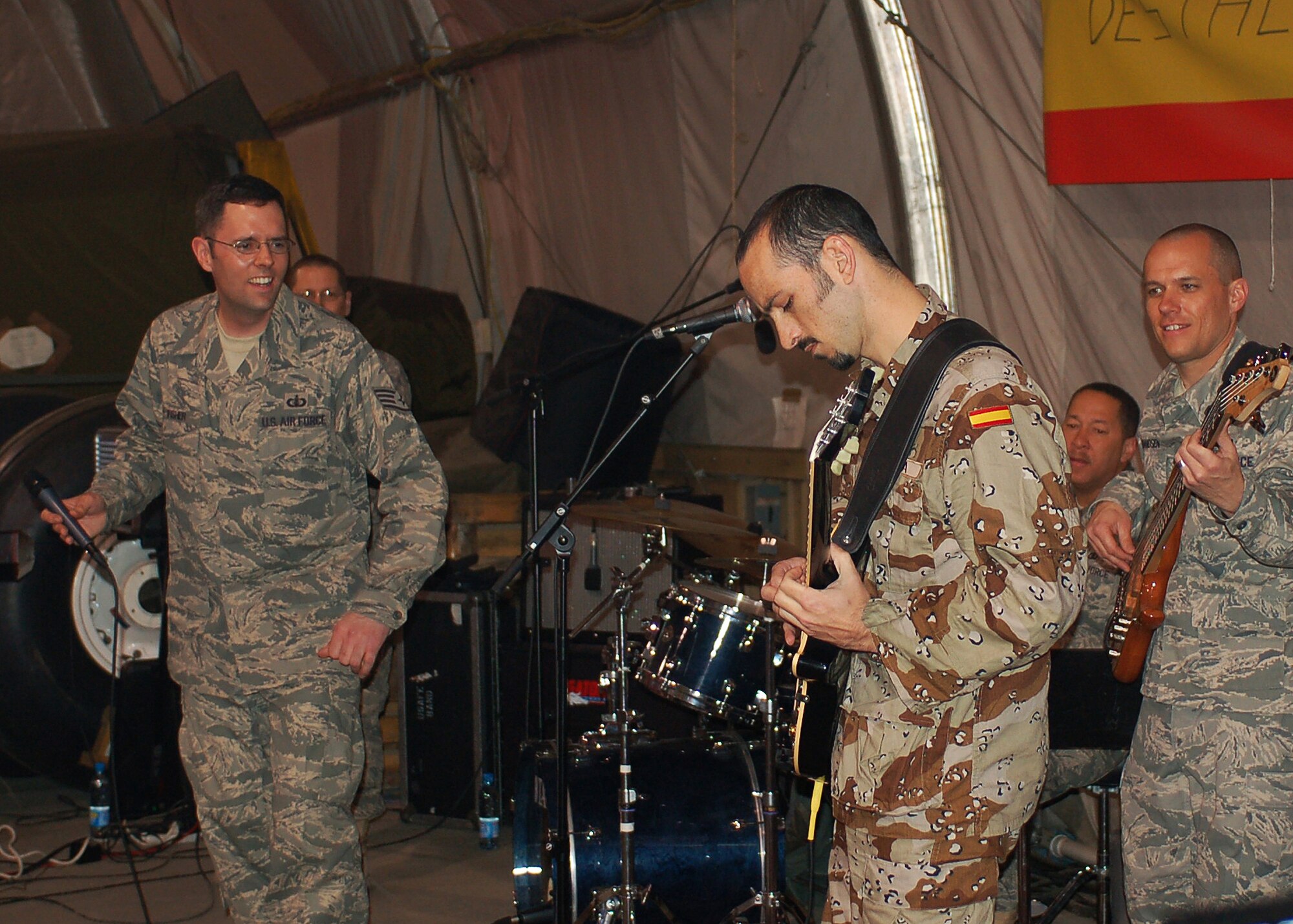 Spanish Air Force member, 2nd Lt. Javier Roa, plays as guest guitarist for the band Sirocco, during the U.S. Air Forces Central Expeditionary Band's last performance March 21 at Manas Air Base, Kyrgyzstan. Sirocco members are deployed to Southwest Asia from the U.S. Air Forces in Europe Band at Sembach AB, Germany. Lieutenant Roa is coalition forces C-130 pilot deployed to Manas from Zaragoza, Spain. (U.S. Air Force photo/Tech. Sgt. Elizabeth Weinberg)