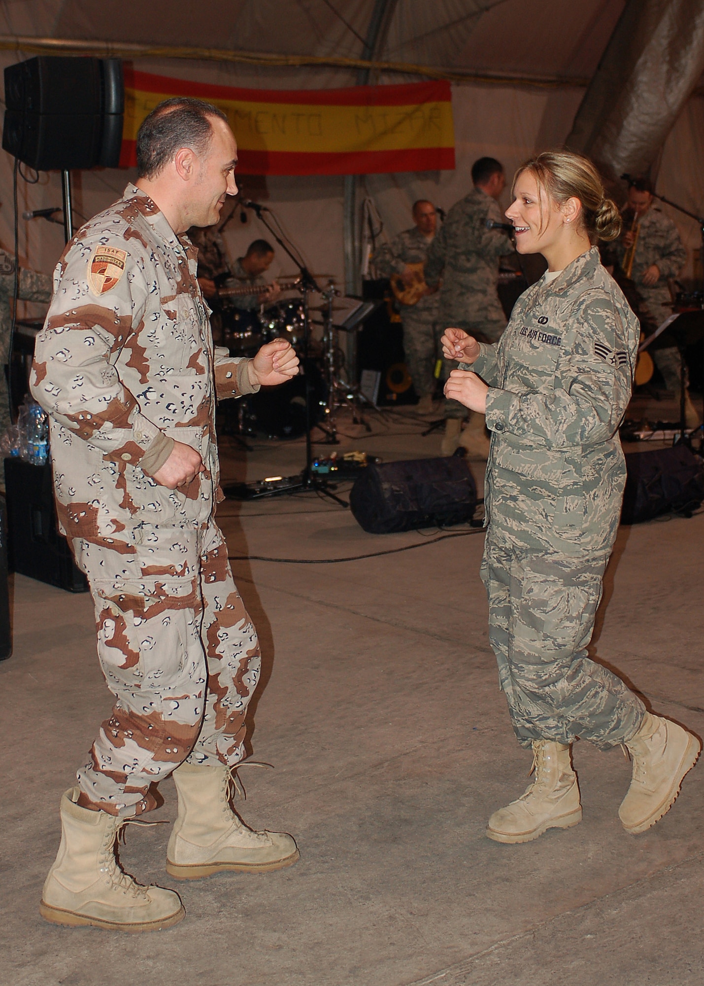 Senior Airman Courtney Clifford dances with a coalition partner at the Spanish Air Force's hangar, Mar. 20, at Manas Air Base, Kyrgyzstan. Airman Clifford is the lead female vocalist for the band Sirocco, the U.S. Air Forces Central Expeditionary Band. The band members are deployed to Southwest Asia from the U.S. Air Forces in Europe Band at Sembach AB, Germany. (U.S. Air Force photo/Tech. Sgt. Elizabeth Weinberg) 