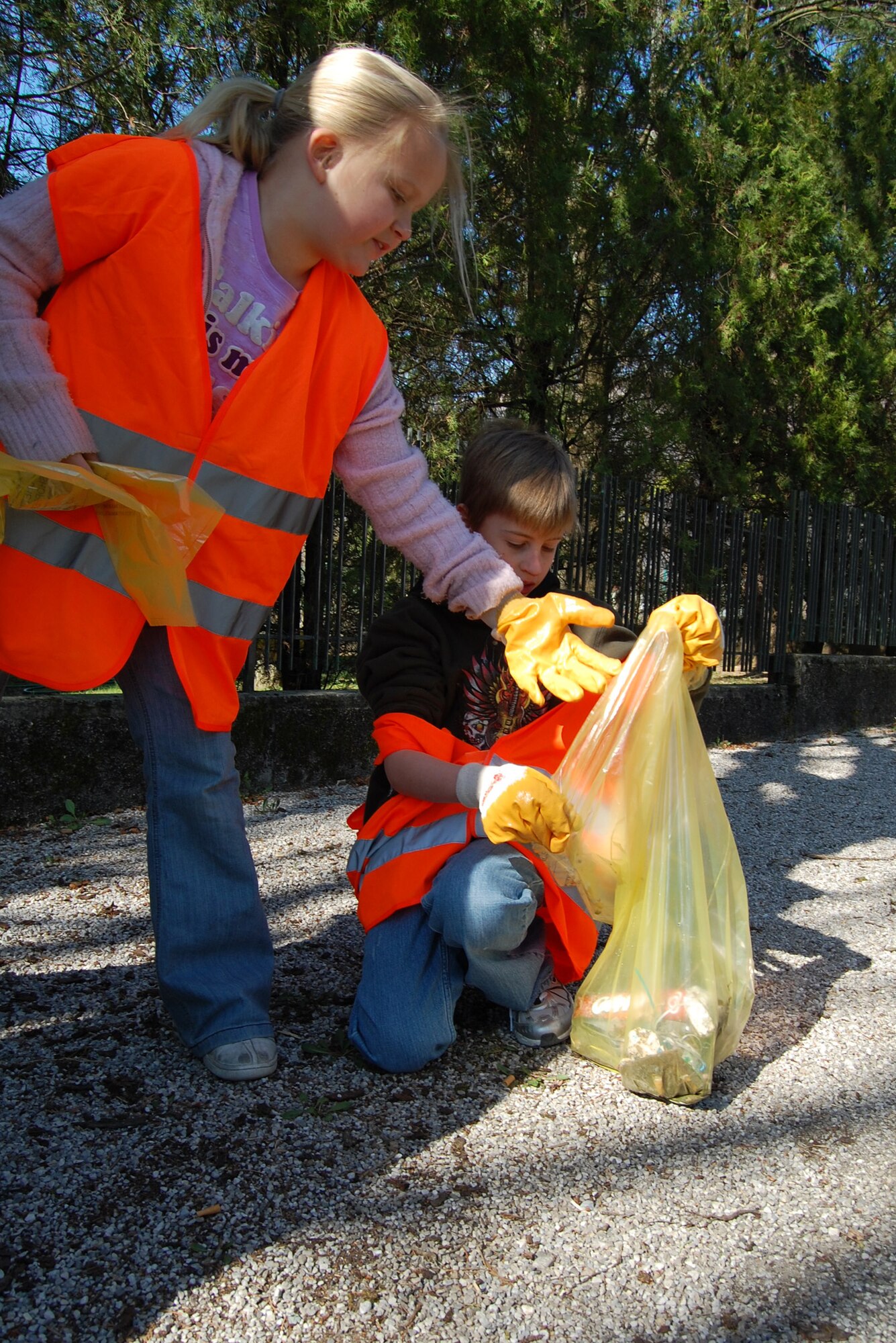 Taylor Keena, daughter of Capt. Lisa and Patrick Keena, and Eo'in Devine, son of Tech. Sgt. Sean and Grace Devine, pick up trash along the Aviano, Italy, roadways March 22. More than 300 Airmen, civilians and family members teamed up with the local community to clean the streets as part of the annual Aviano Ecological Day. (U.S. Air Force photo/Staff Sgt. Lindsey Maurice)
