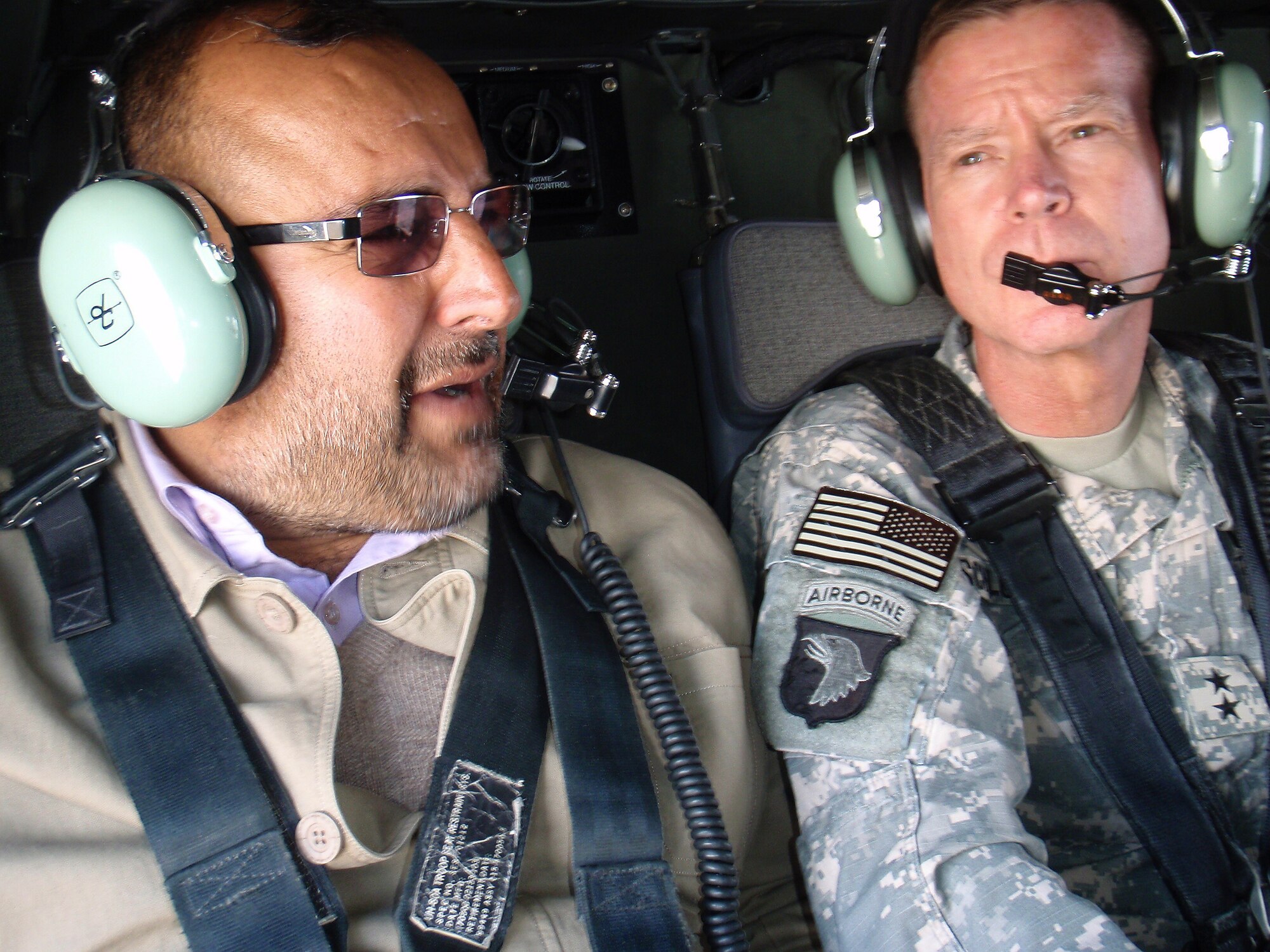 Aboard a UH-60 Blackhawk, Panjshir Governor Alhaj G. Bahlol and Maj. Gen. Jeffrey Schloesser, Combined Joint Task Force-101 and Regional Command - East commanding general, discuss details of Panjshir?s future paved road that will lead north to Badakshan. This road, once completed, will improve the provincial government?s ability to reach its people and link major commerce and district government centers between the province?s seven districts. (U.S. Air Force photo by Lt. Col. Mark Stratton)
