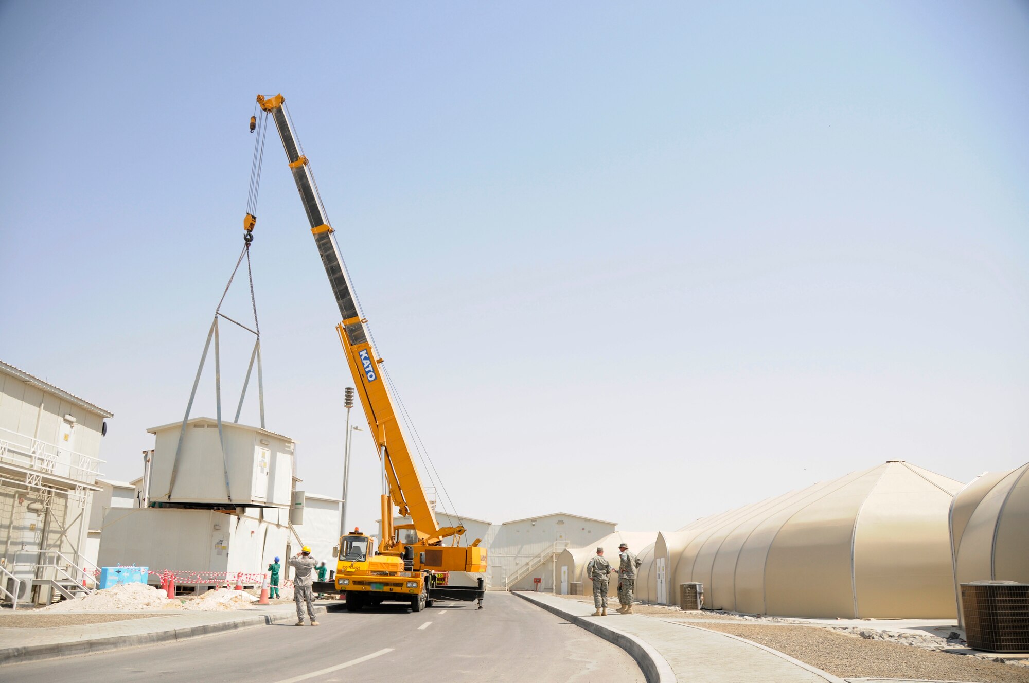 SOUTHWEST ASIA - A crane operated by a third country national lifts a section of the second story of a building onto its base, Mar 19. The building is used for lodging where new Airman and Soldiers can acquire room assignments and keys as well as pick-up linen for their beds. Lodging is also responsible for bedding down any distinguished visitors or diverted flight members to ensure their comfort. The lodging building was moved to make room for dormitory expansion. (U.S. Air Force photo by Senior Airman Brian J. Ellis) (Released)