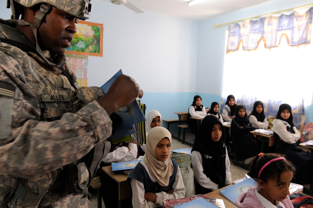 U.S. Army Maj. Richard Allen assists Iraqi soldiers in handing out donated school supplies to students at the Khawr Az Zubayar primary school in the Az Zubayar District in Basra, Iraq, March 17, 2009. Allen is assigned to the 304th Civil Affairs Brigade.