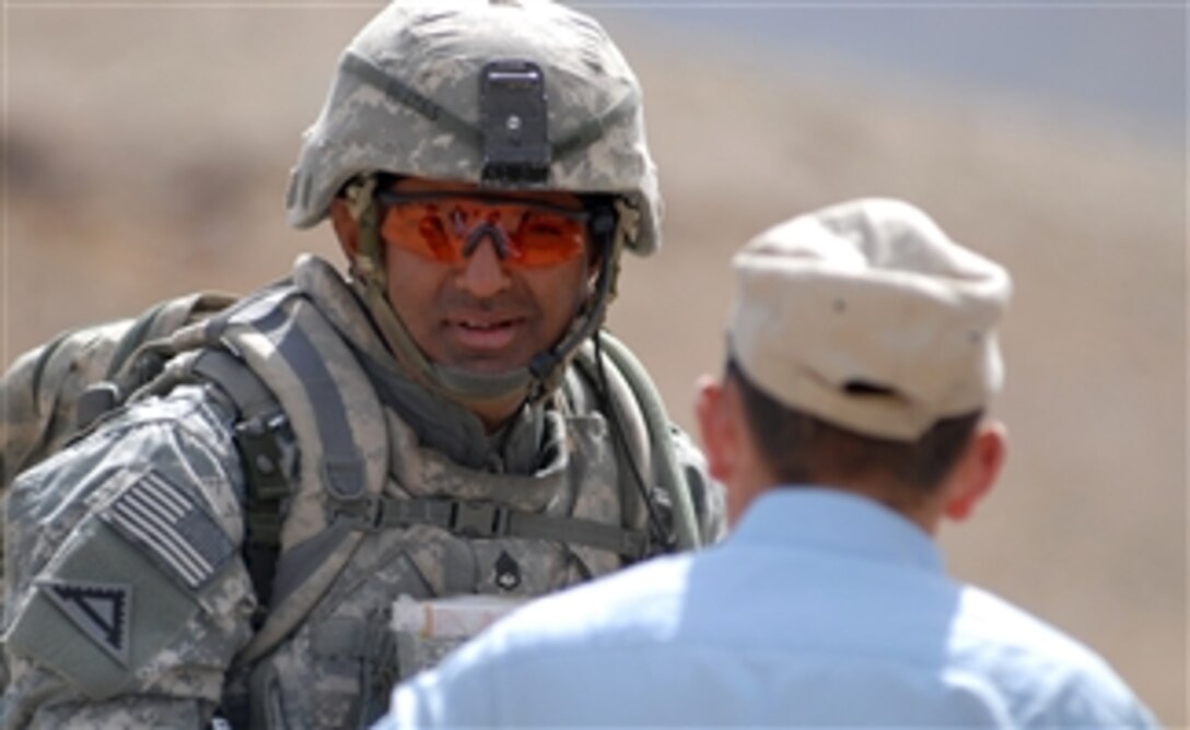 U.S. Army Staff Sgt. Azhar Sher from Bravo Company, 1st Battalion, 4th Infantry Regiment, U.S. Army Europe speaks with an Afghan National Police officer at the district center near Forward Operating Base Baylough in the Zabul province of Afghanistan on March 20, 2009.  