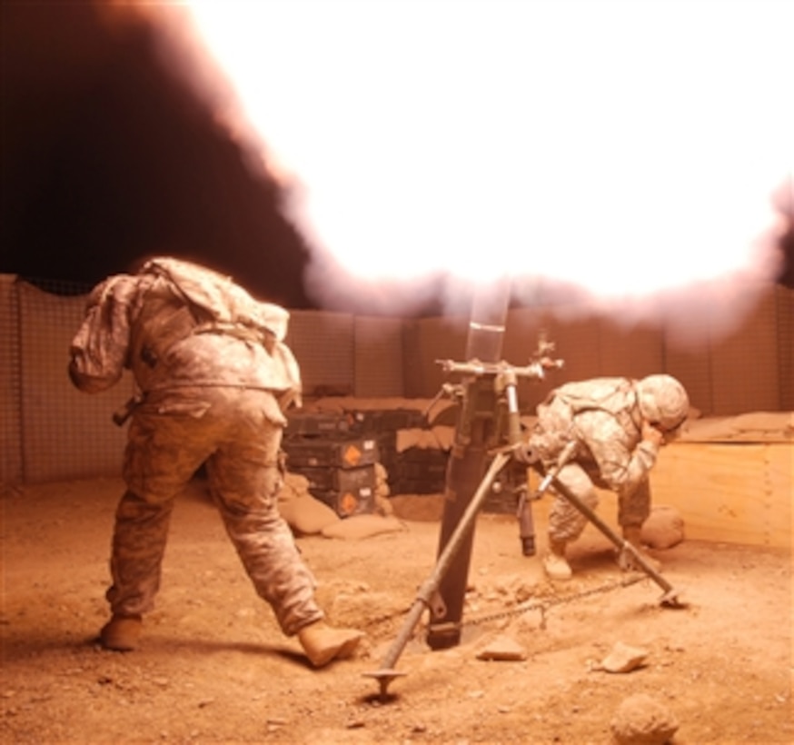 U.S. Army Spcs. Spositi and Bugher, both from U.S. Army Europe's Bravo Company, 1st Battalion, 4th Infantry Regiment, fire a 120 mm illumination round in celebration of the Afghan New Year at Forward Operating Base Baylough in the Zabul province of Afghanistan on March 19, 2009.  