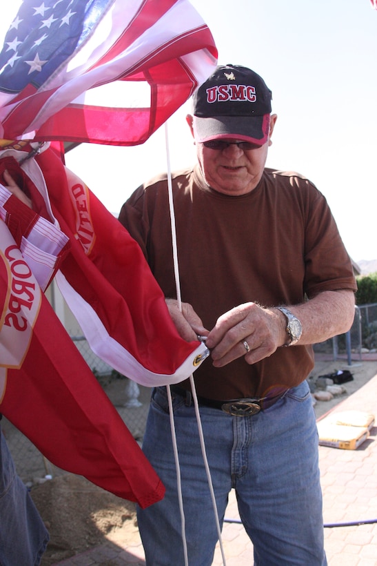 Korean War veteran Richard N. Blasongame attaches the Marine Corps flag to his new flagpole that was constructed by three Marines of 3rd Combat Engineers Battalion, March 25.