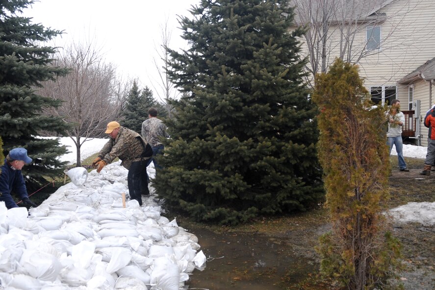 Volunteers and neighbors work together to protect homes from rising flood waters in a Fargo, N.D., neighborhood. Many Grand Forks Air Force Base teammates have volunteered throughout the region in support of flood protection efforts. (U.S. Air Force photo/Tech. Sgt. Amanda Callahan)