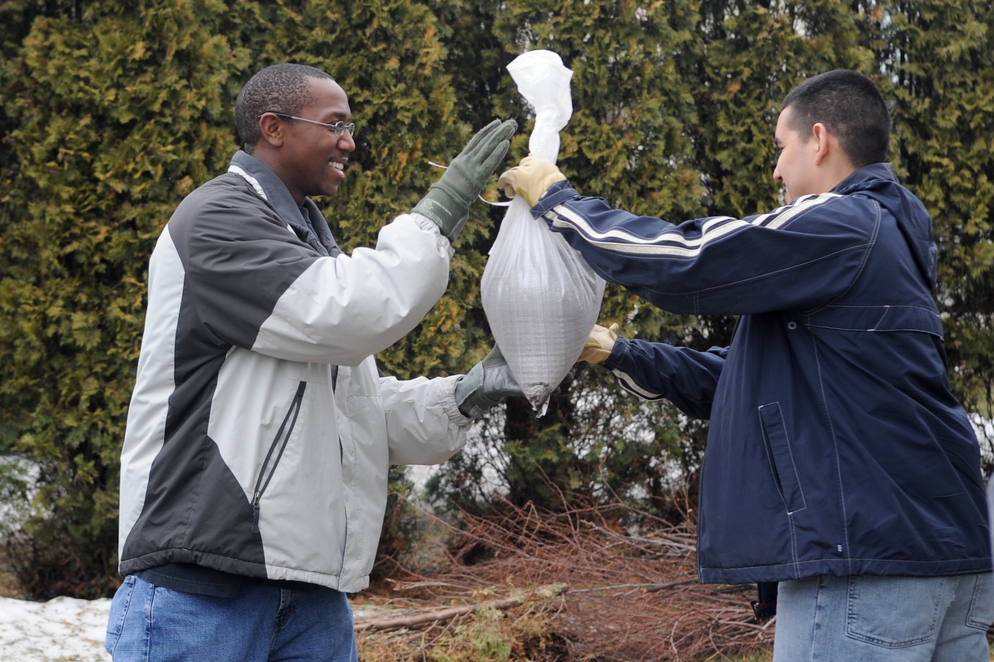 Staff Sgt. Nathaniel Newkirk (left) and Senior Airman Isaac Zavala, both of the 319th Operations Support Squadron, are part of a human sandbag chain comprised of neighbors and volunteers in Fargo, N.D. Warriors of the North are supporting the flood preparation efforts by volunteering at many locations throughout the Red River Valley. (U.S. Air Force photo/Tech. Sgt. Amanda Callahan)