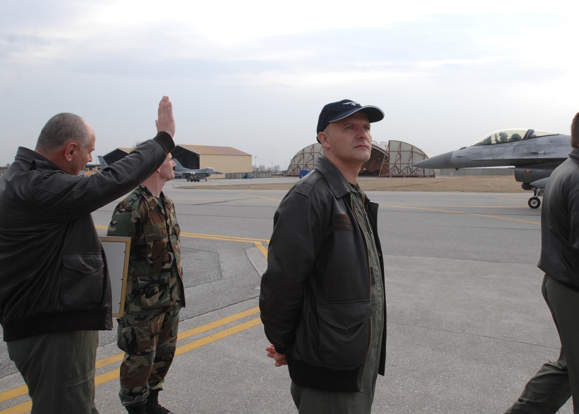 A member of the Croatian air force waves to a U.S. pilot taxing to a parking spot following a training mission here March 17. Nine members from Croatia's air force visited the base as part of the United States Air Forces Europe 'Building Partnership Capacity' program.  During their visit, they met with Airmen from the 31st Operations and Maintenance Groups to gain insight on how the U.S. Air Force conducts operations. (U.S. Air Force photo/Staff Sgt. Patrick Dixon)