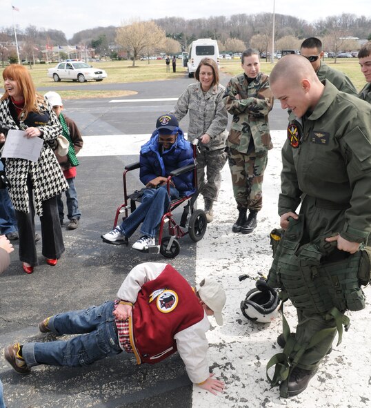 A  Make-A-Wish child proves how strong he is by doing one-armed push-ups for everyone to see March 20 on Bolling. The Make-A-Wish Foundation has been granting wishes to children with progressive, degenerative or malignant conditions since 1980 and has reached more than 167,000 children around the world. (U.S. Air Force photo by Senior Airman Sean Adams)