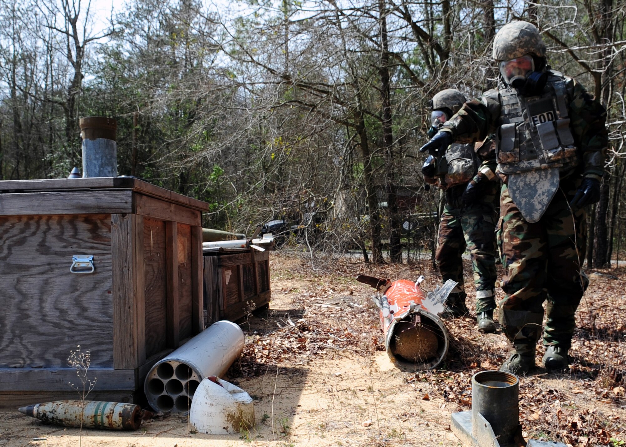 Airman 1st Class Brandon Martin (foreground) points out a simulated leaking chemical explosive to Senior Airman Cooper Gibson, both are explosive ordinance disposal specialists with the 4th Civil Engineer Squadron, during a training exercise on Seymour Johnson Air Force Base, N.C., March 19, 2009. Airmen Martin and Gibson have identified and disposed of the explosive in a timely and safe manner. (U.S. Air Force Photo by Airman 1st Class Rae Perry)