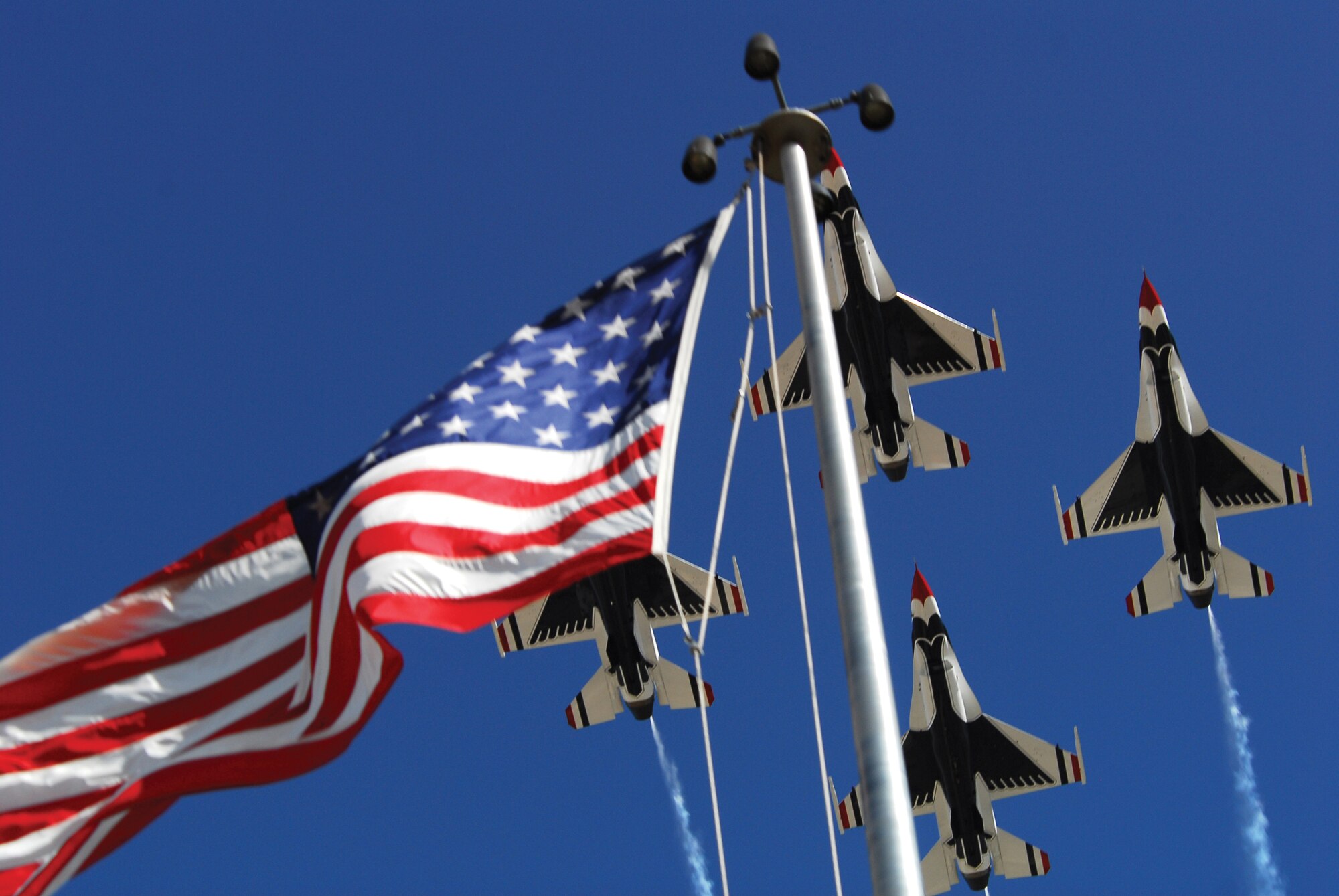 The U.S. Air Force Thunderbird Aerial Demonstration Team’s F-16 Fighting Falcons fly past the Luke Air Force Base base flag pole during the 2009 Thunder in the Desert Air Show and Open House, March 21. The event jump started the Thunderbirds 2009 air show season. (U.S. Air Force photo/Airman 1st Class Tracie Forte)