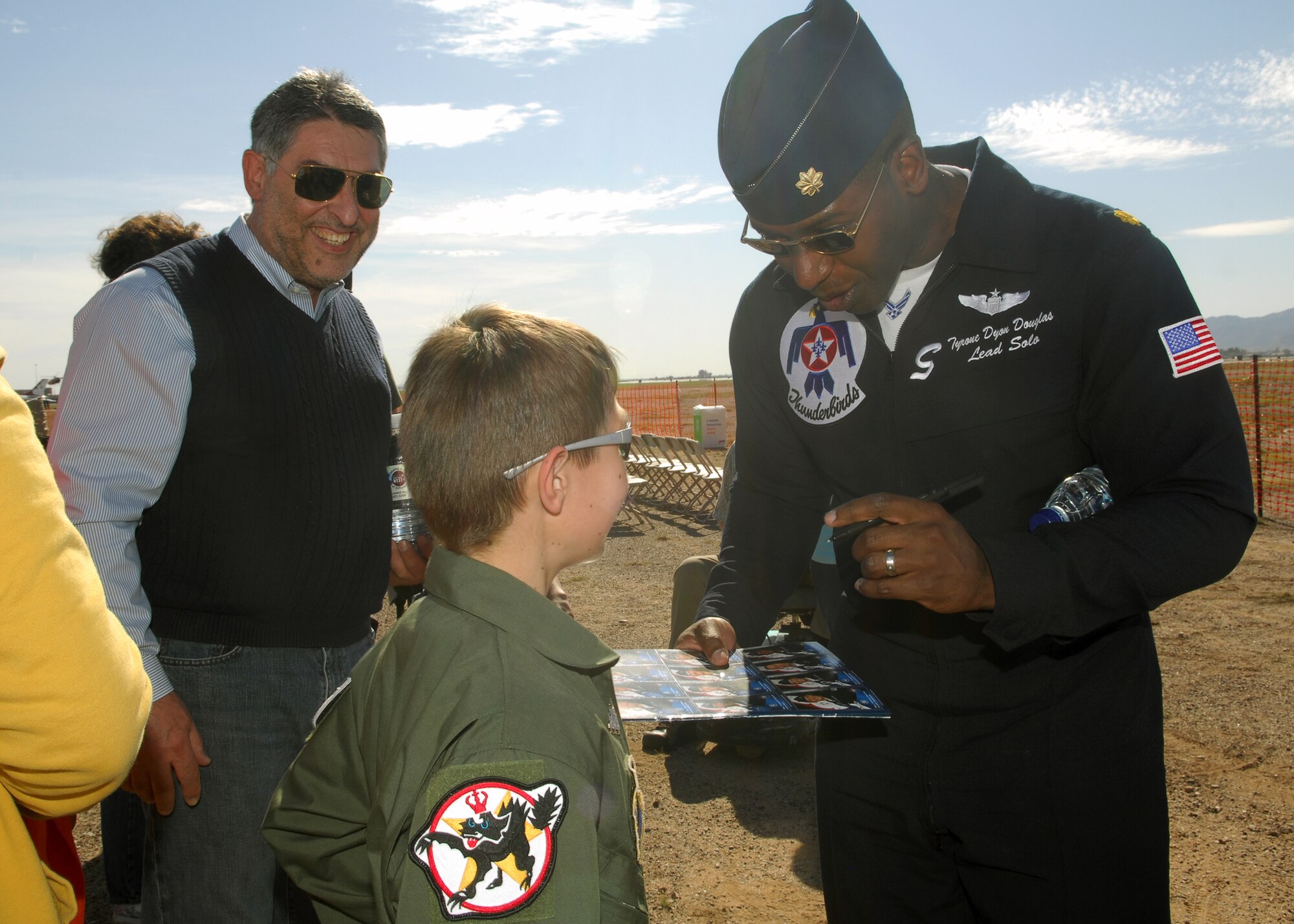 Maj. Tyrone Douglas, Thunderbirds lead solo pilot, signs an autograph for an enthusiastic fan when the Thunderbirds meet with Make-a-wish children from the local area on March 20. More than 150 children and their families had an opportunity to meet with the pilots. (U.S. Air Force photo Tech. Sgt. Raheem Moore)