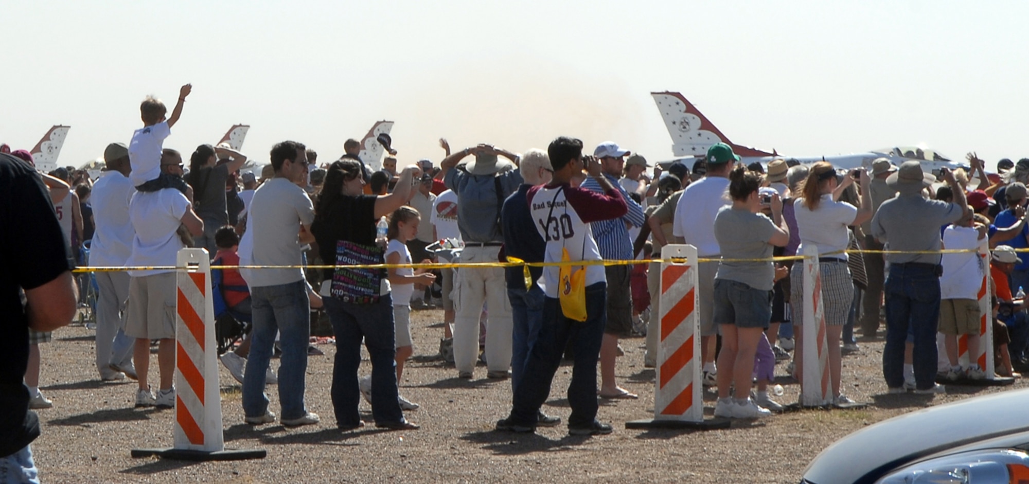 Ryan Pearson holds his son, Bryson, on his shoulders as he waves to the U.S. Air Force Thunderbird Aerial Demonstration Team during the 2009 Thunder in the Desert Air Show March 22. (U.S. Air Force photo/Airman 1st Class Ronifel Yasay) 