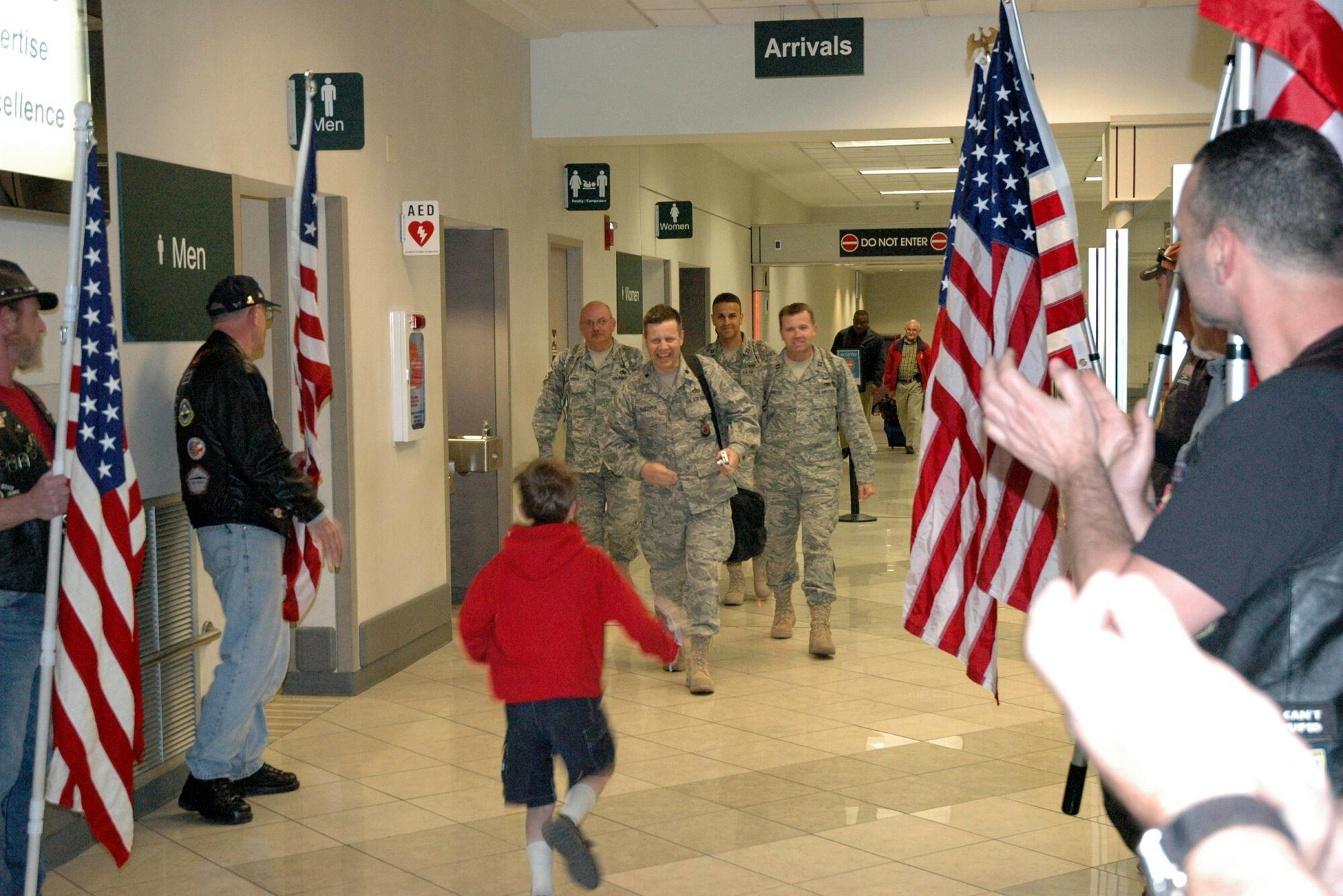 WRIGHT-PATTERSON AFB, Ohio – Lt. Col. Thomas Kuepper, Commander, 445th Civil Engineer Squadron, is greeted at the airport by his son and members of the Ohio Patriot Guards after returning from a 6-month deployment to Iraq.  Lt. Col. Kuepper and three other CE Airmen returned March 16.  A group of 60 Civil Engineer Airmen returned to the base March 15. (Courtesy photo/CJ Spencer)   