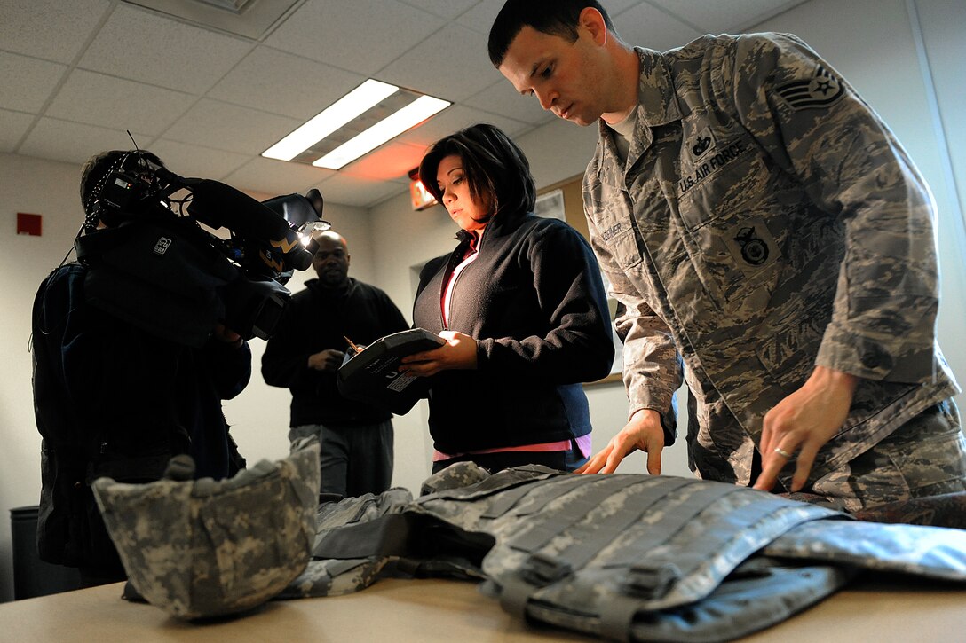 LANGLEY AIR FORCE BASE, Va. -- Staff Sgt. Joshua Finkbeiner, 1st Security Forces Squadron readiness technician, prepares a protective vest for Mrs. Bianca Martinez, WTKR Channel 3 broadcaster, before educating her on the advantages of proper protection as a patrolmen, here March 23.  Mrs. Martinez started a series entitled "Do My Military Job," which allows her to learn about various jobs within each branch of the military.  (U.S. Air Force photo/Senior Airman Vernon Young)