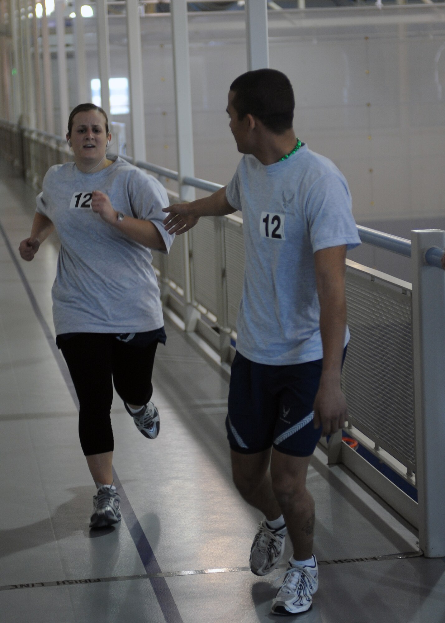 MINOT AIR FORCE BASE, N.D. -- Senior Airman Amber Volpi and Airman 1st Class Allen Simms, members of the 5th Logistics Readiness Squadron team, compete in the St. Patrick's Day 6-mile relay race at the McAdoo Fitness Center here March 17. The Relay race consisted of four team members (at least one female) and each member was required to run 1.5 miles. (U.S. Air Force photo by Senior Airman Sharida Jackson)
