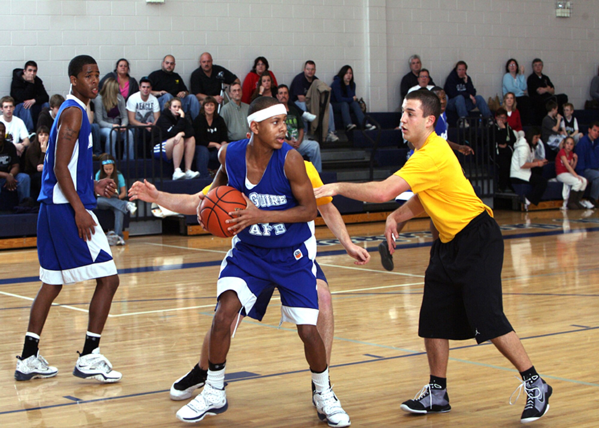 McGuire Falcons senior point guard and team captain Marcell Hughes, son of Master Sgt. Marcus Hughes of the U.S. Air Force Expeditionary Center's 421st Combat Training Squadron, secures a rebound during play in a state semi-final game.  Marcell, along with his brother Marcus, helped lead the Falcons to the 2009 New Jersey Catholic Youth Organization High School Basketball Championship at St. Leo the Great High School in Lincroft, N.J.  The Falcons are the first team from Burlington County, N.J., to win the state title since 2000 and the first-ever youth team from McGuire to win. (Courtesy Photo) 
