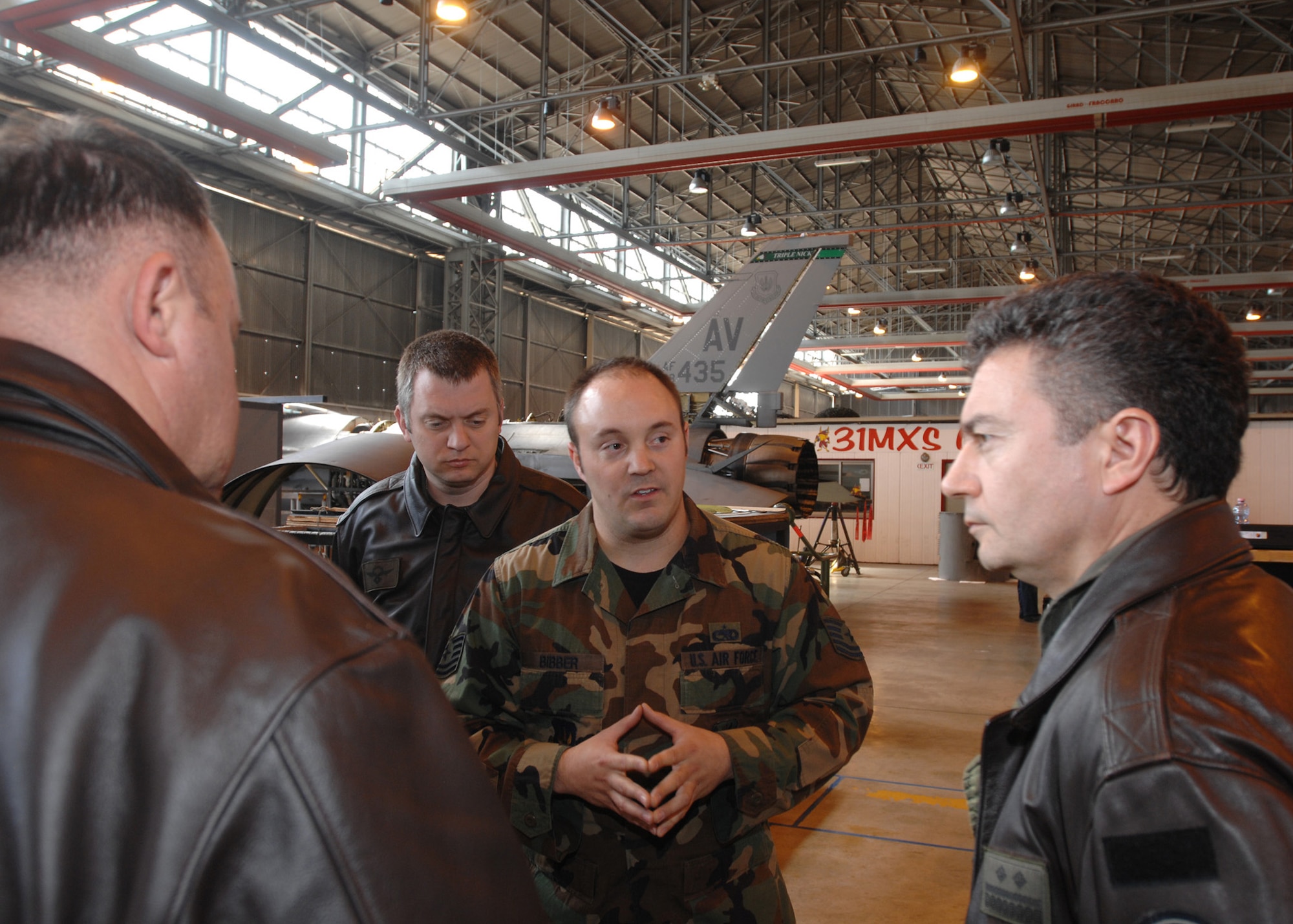 Tech. Sgt. Derek Bibber, a phase inspection dock chief for the 31st Maintenance Squadron, talks about scheduled maintenance practices in the Air Force with Croatian air force officers during a visit here March 17.  For every 400 hours of flying hours on an F-16, five-plus days of phase maintenance is performed to strip the aircraft apart, perform routine and preventative maintenance, and to put the aircraft back together.  (U.S. Air Force photo/Staff Sgt. Patrick Dixon)