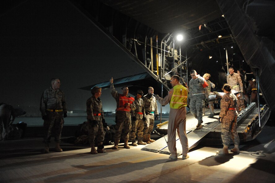 Airmen from the 332nd Expeditionary Operations Support Squadron's Expeditionary Aeromedical Evacuation Flight and the 332nd Expeditionary Medical Group Contingency Aeromedical Staging Facility along with volunteers wait with stretchers and buses to off-load patients at Joint Base Balad, Iraq, after an aeromedical evacuation mission Feb. 27, 2009. The 332nd EAEF transports servicemembers wounded, injured or sick from remote locations to a higher level of medical care. (U.S. Air Force photo/Senior Airman Elizabeth Rissmiller)