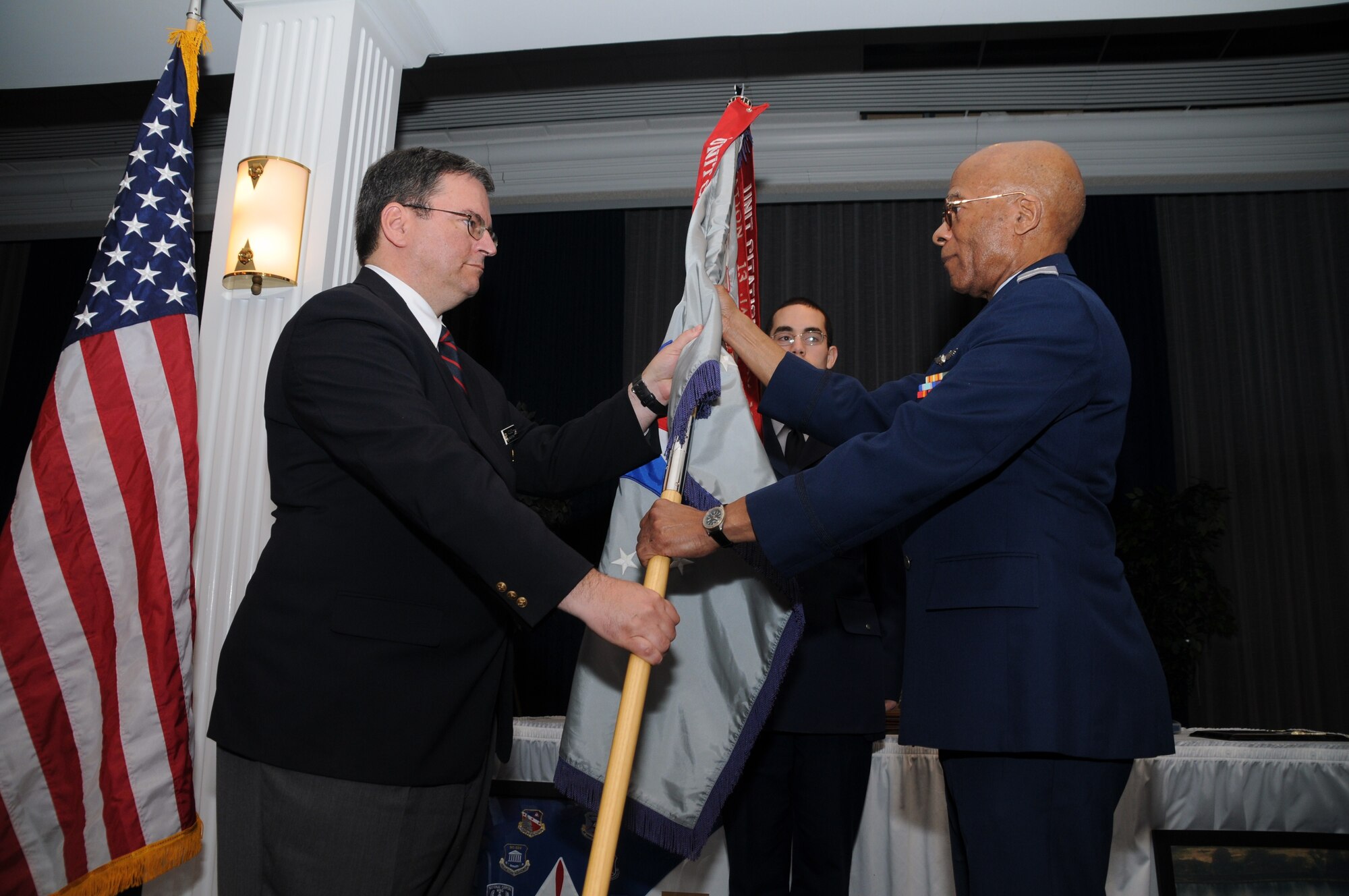 Col. Richard Cooper, right, accepts CAP’s National Capital Wing flag from Middle East Region Commander Col. Joseph Vazquez, left, to symbolize the official transfer of command March 14 at the Bolling Club. (Photo by C. Todd Lopez)